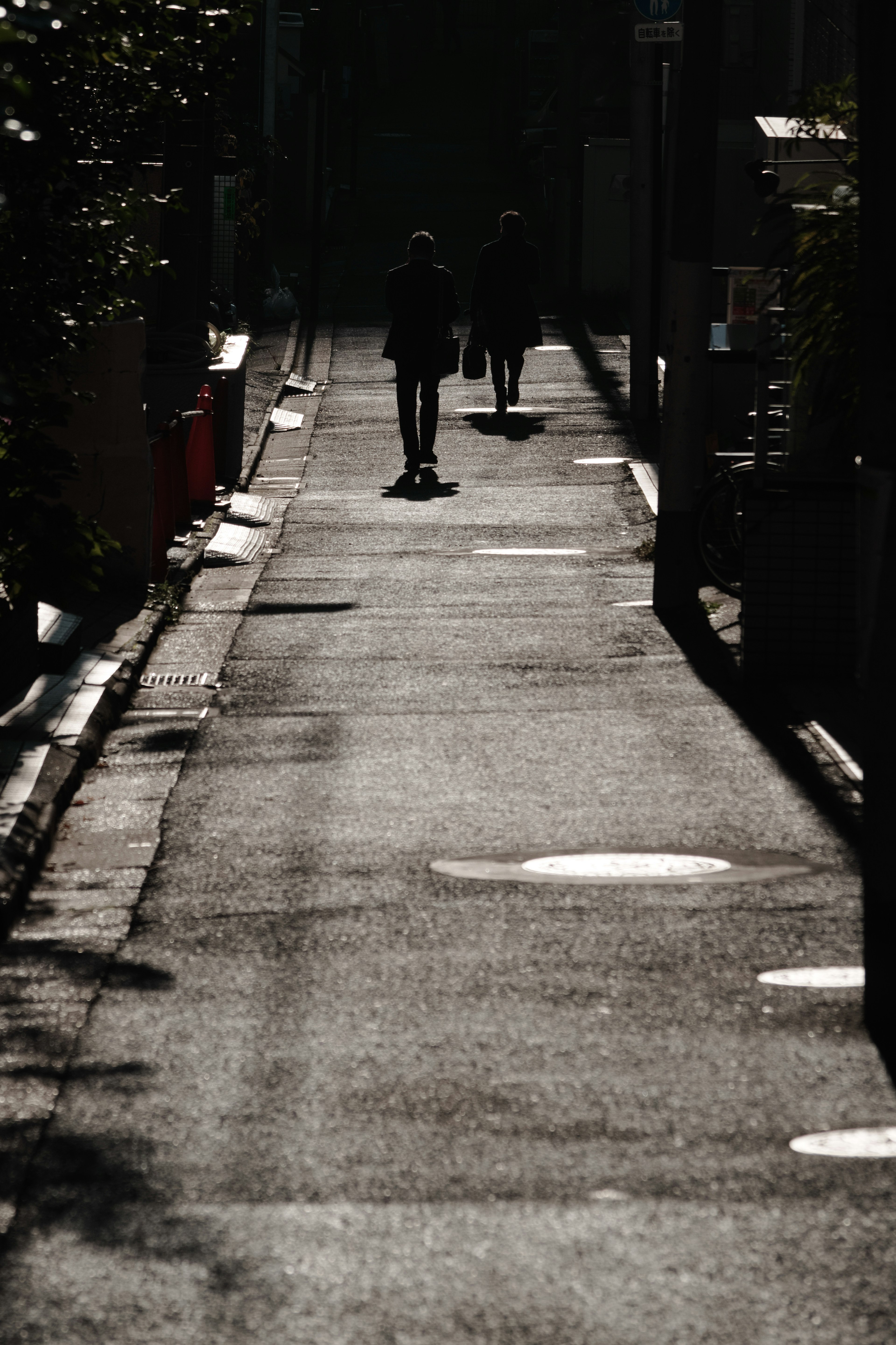 暗い通りに影が映る人々