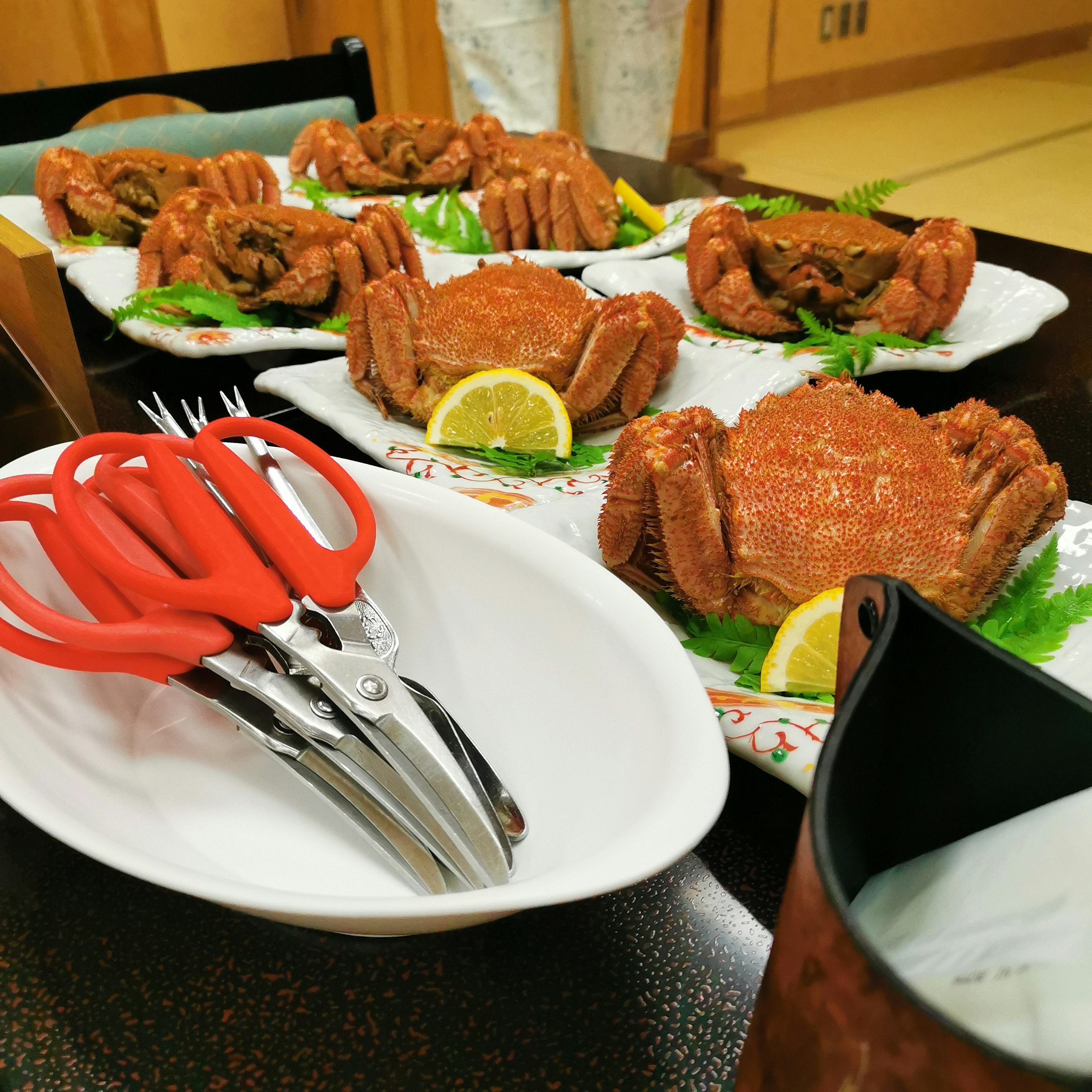 Une table avec des plats de crabe délicieux et des ciseaux rouges