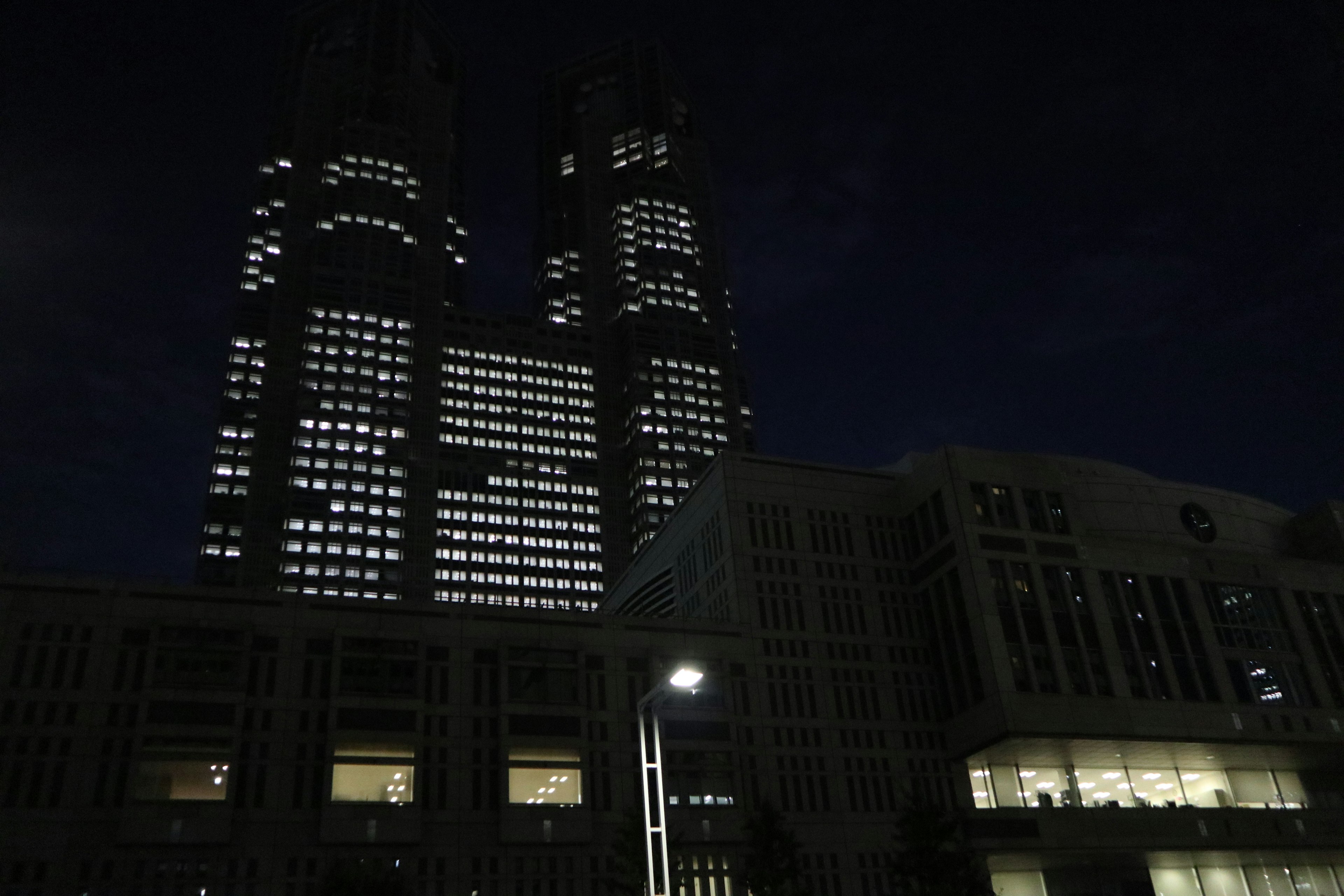 Pemandangan malam gedung pencakar langit Tokyo dengan jendela yang menyala