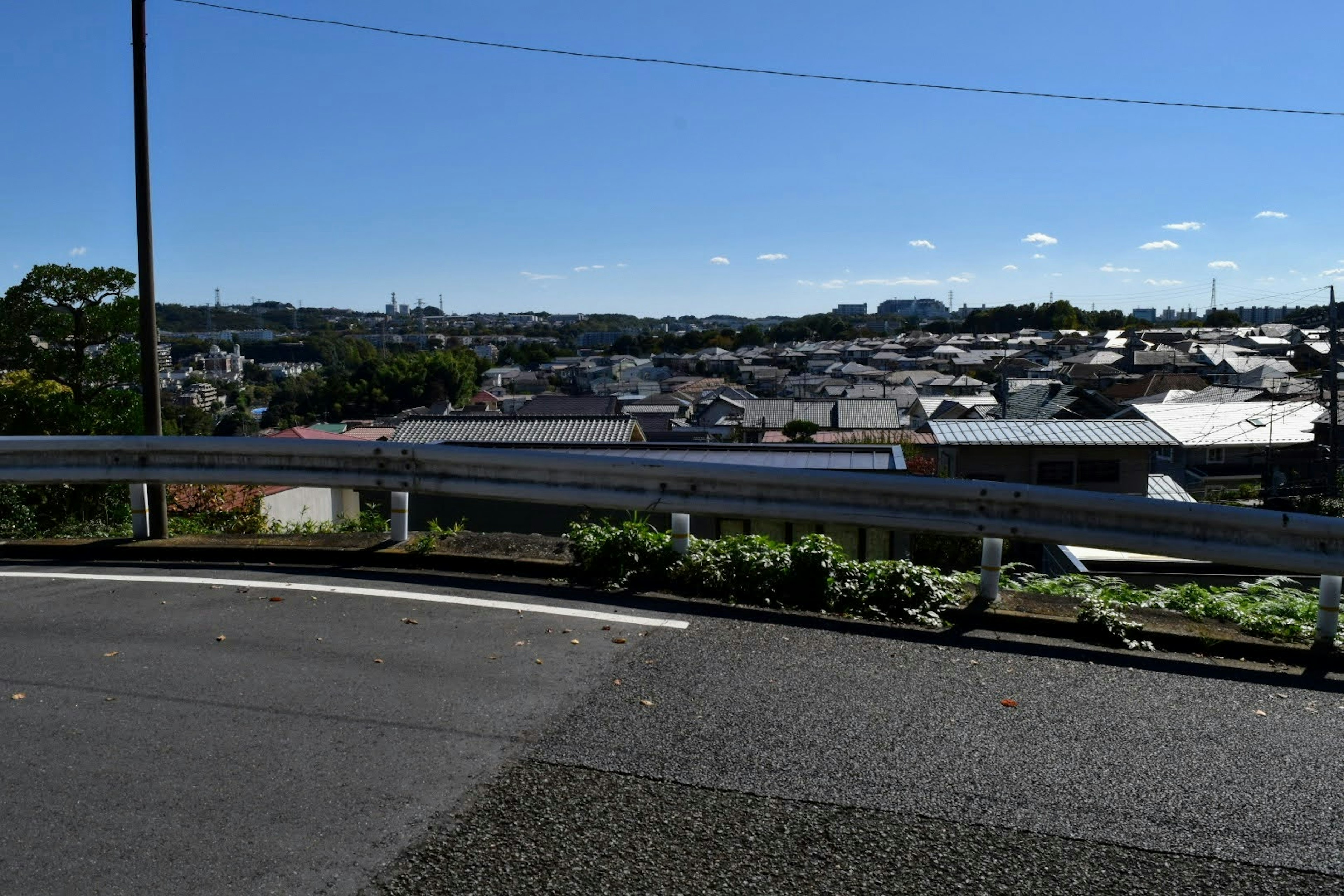 Urban landscape under a blue sky with a section of road