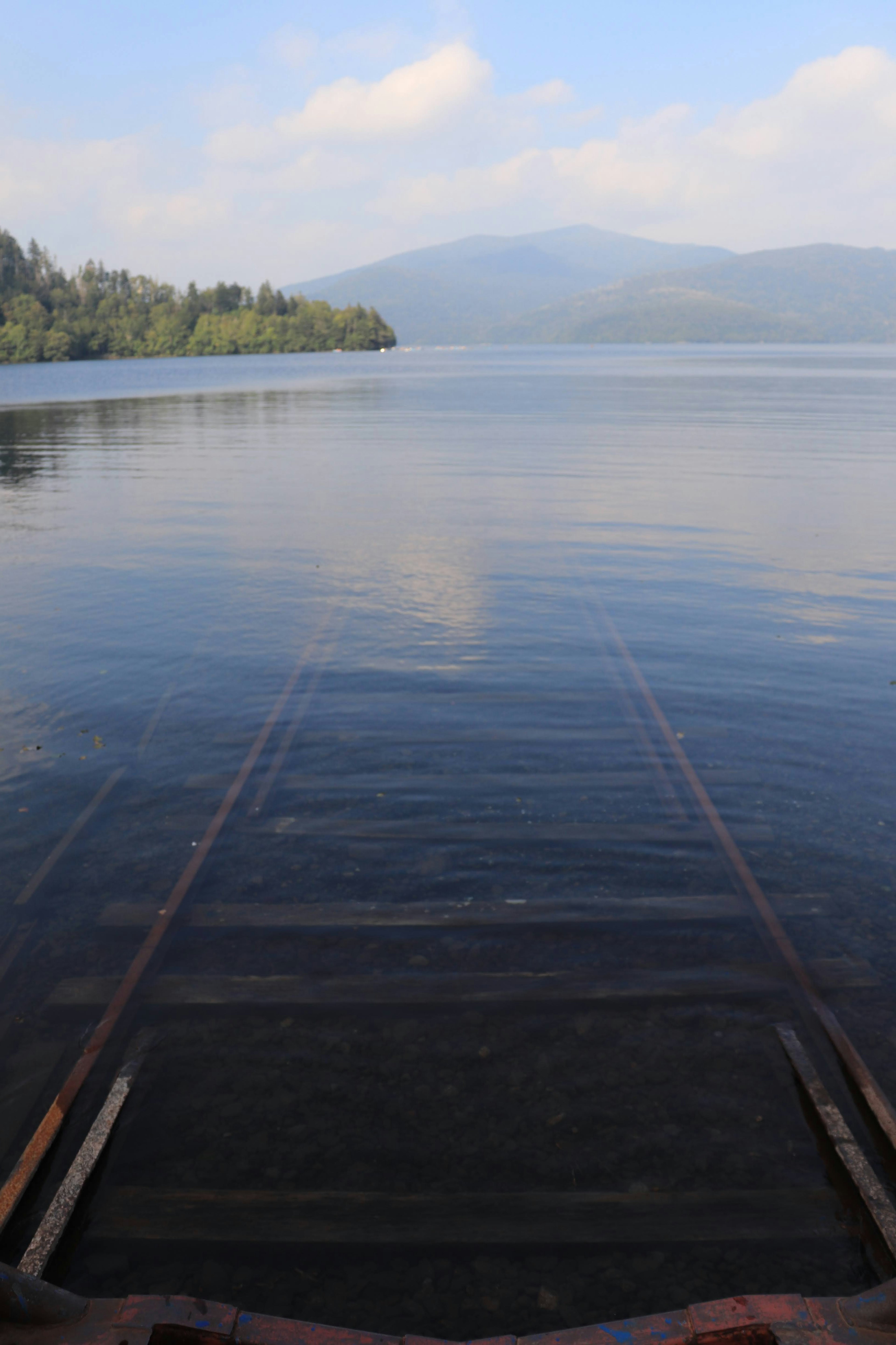 Ruhige Seelandschaft mit Bergen im Hintergrund, die sich im Wasser spiegeln