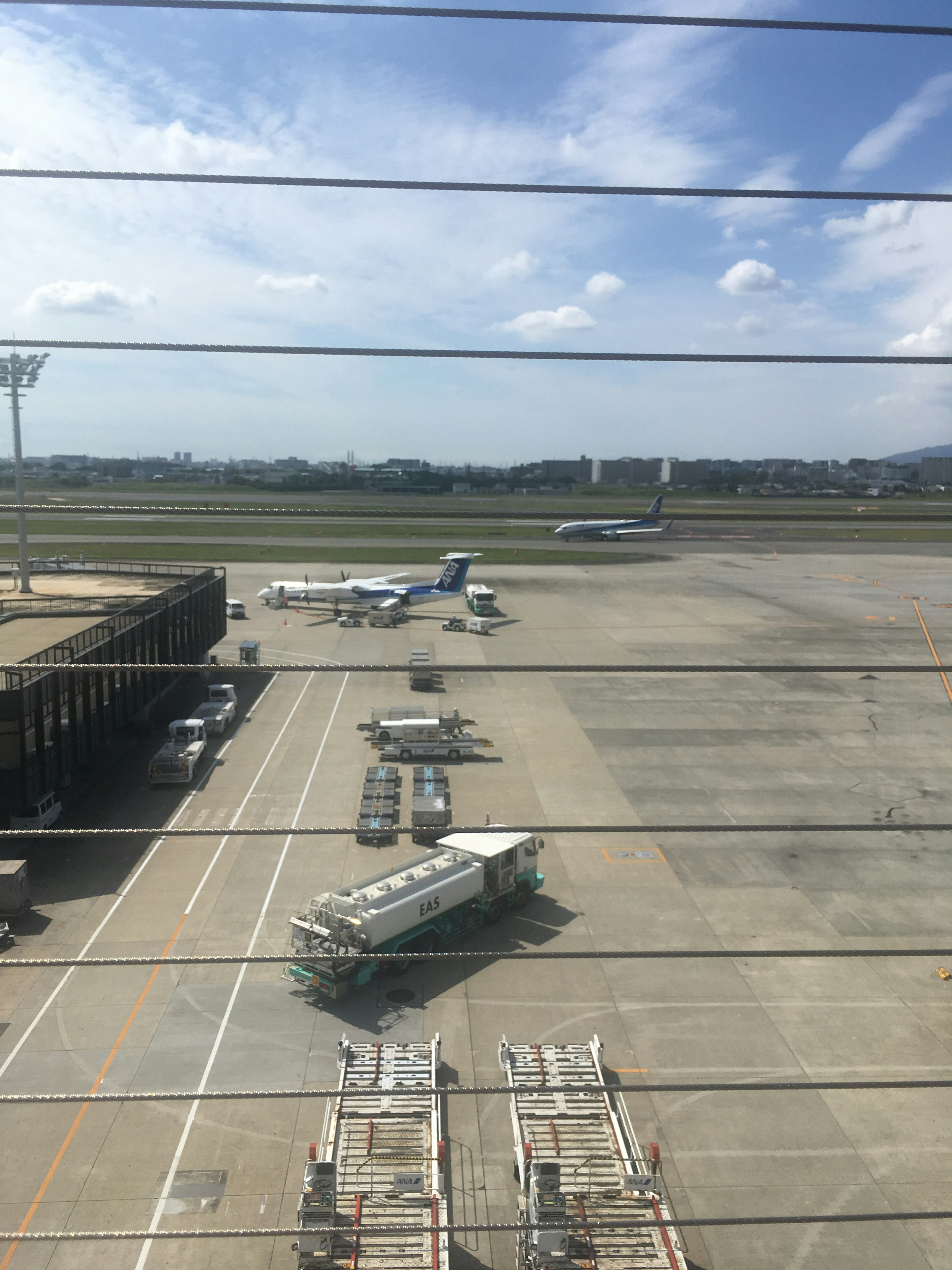 Airplanes parked on an airport runway under a blue sky