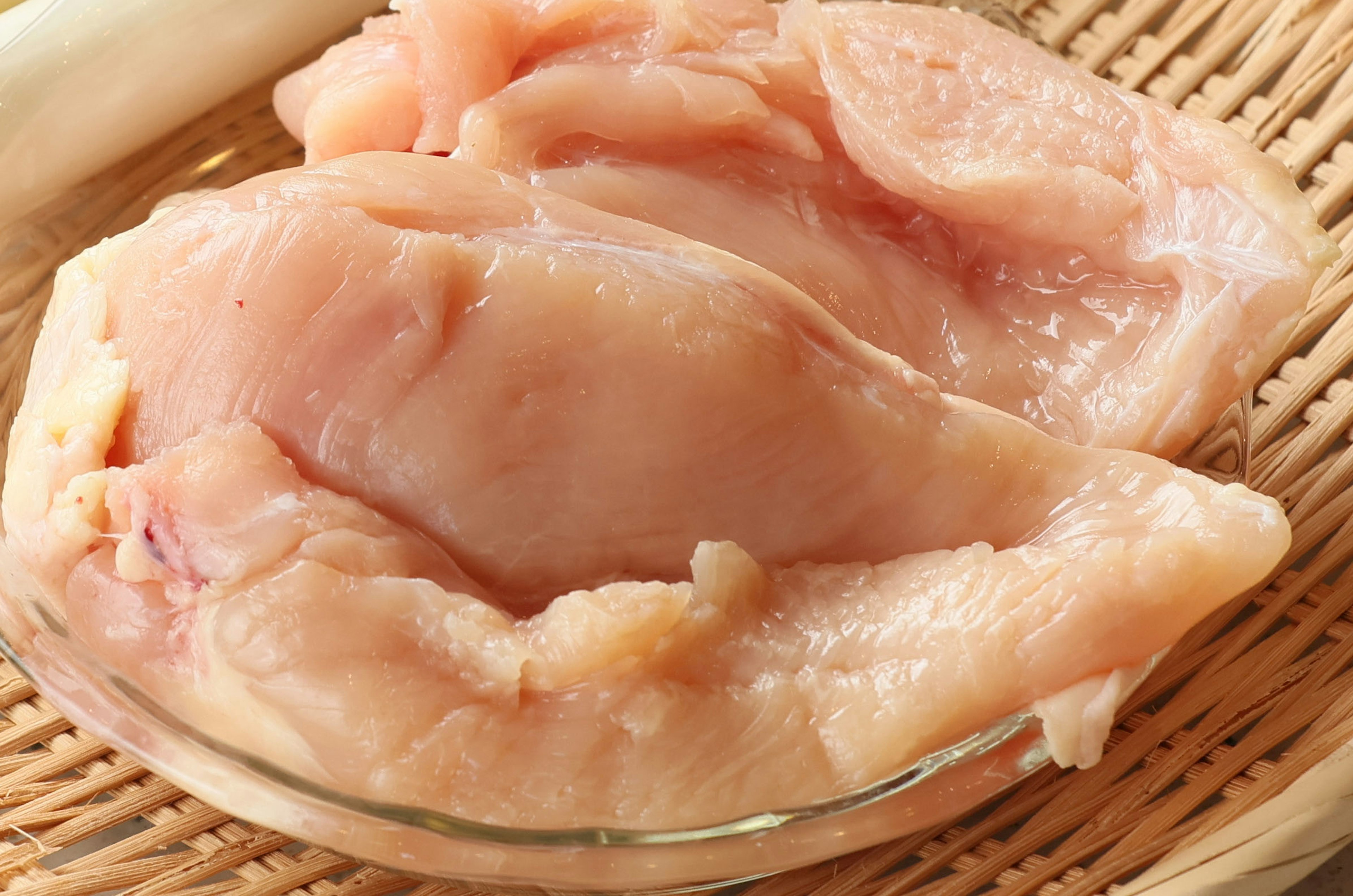 Fresh chicken breast placed in a glass dish