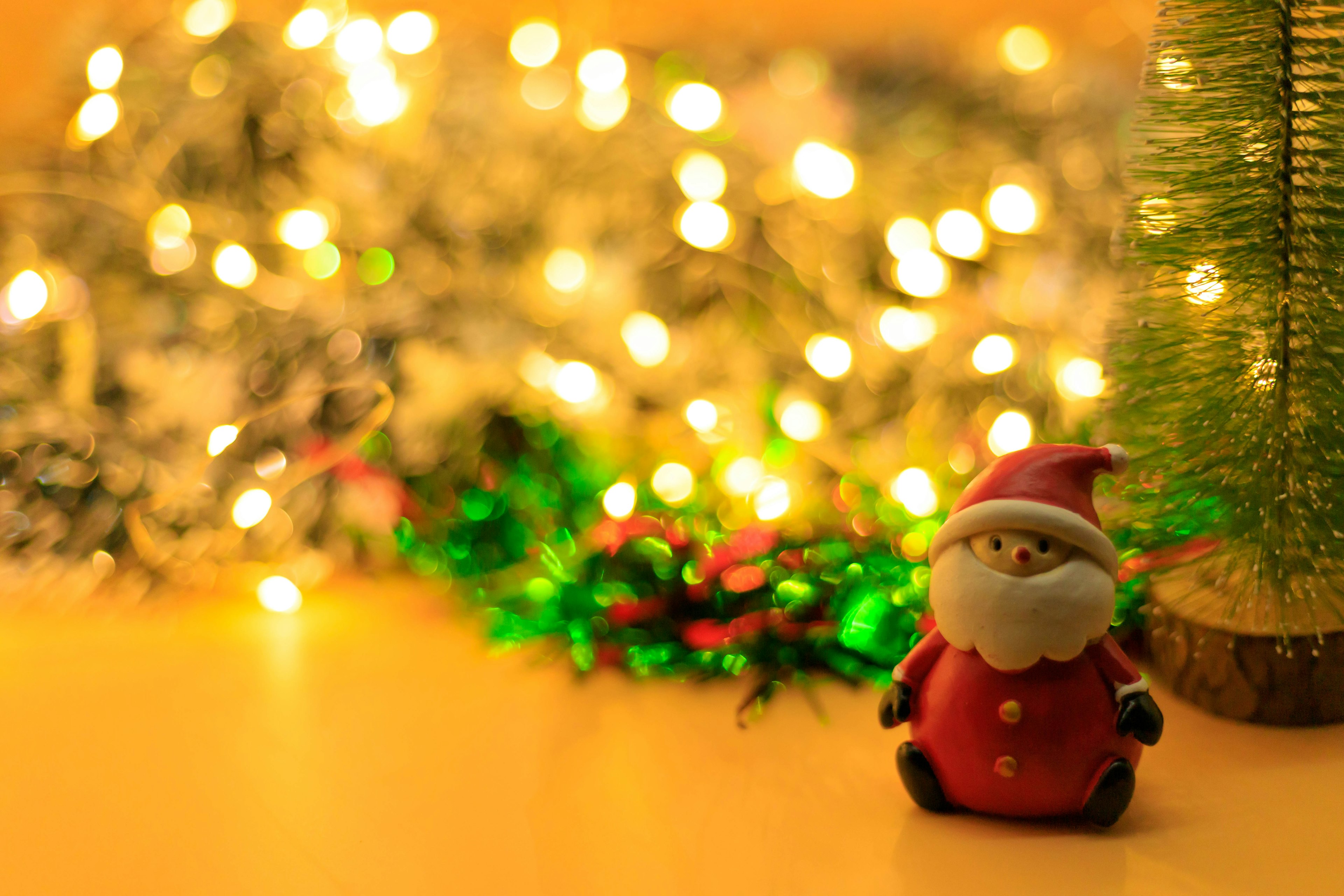 Christmas decoration scene featuring a Santa Claus figure with bright lights in the background