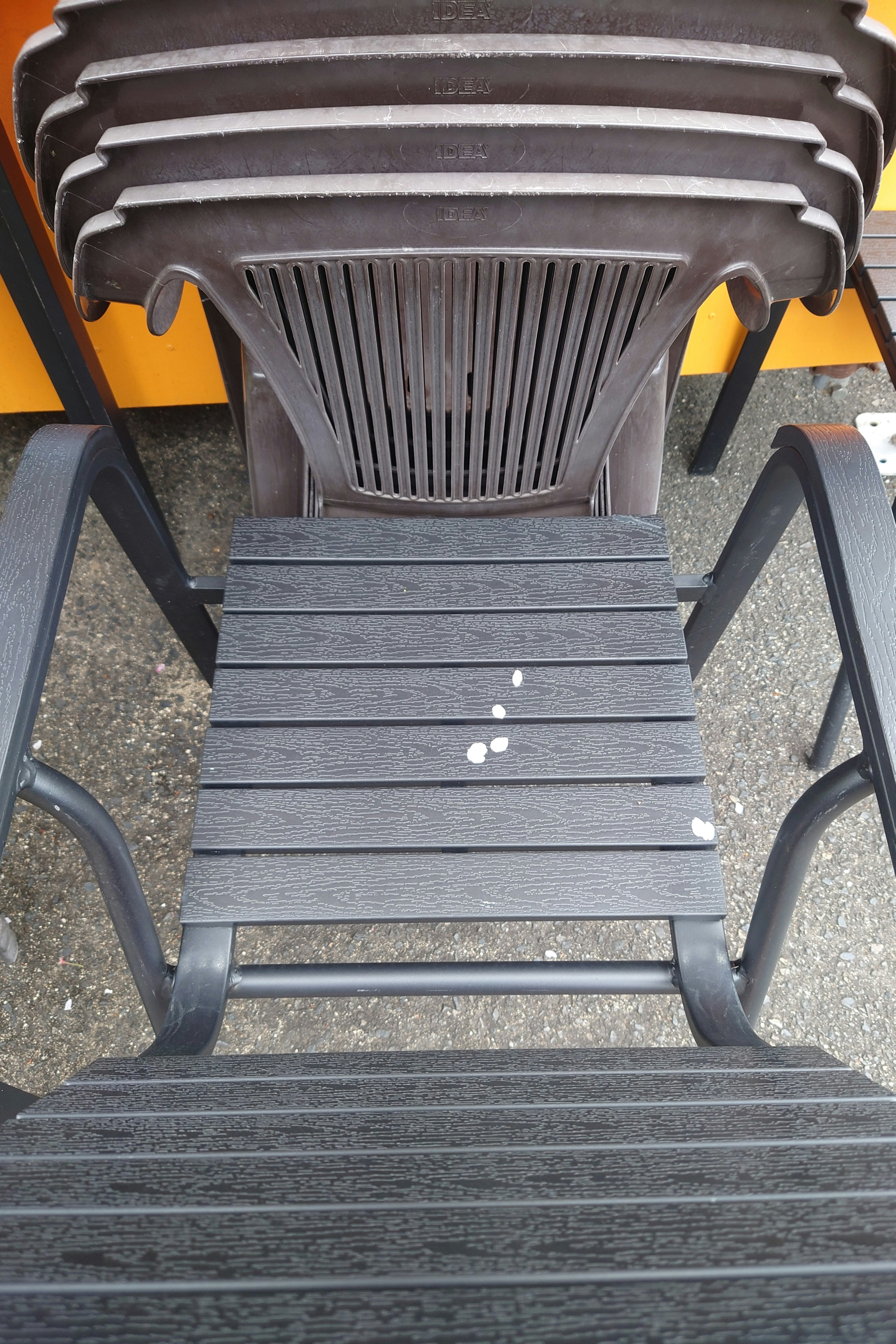 Stacked black plastic chairs with a focus on the top chair