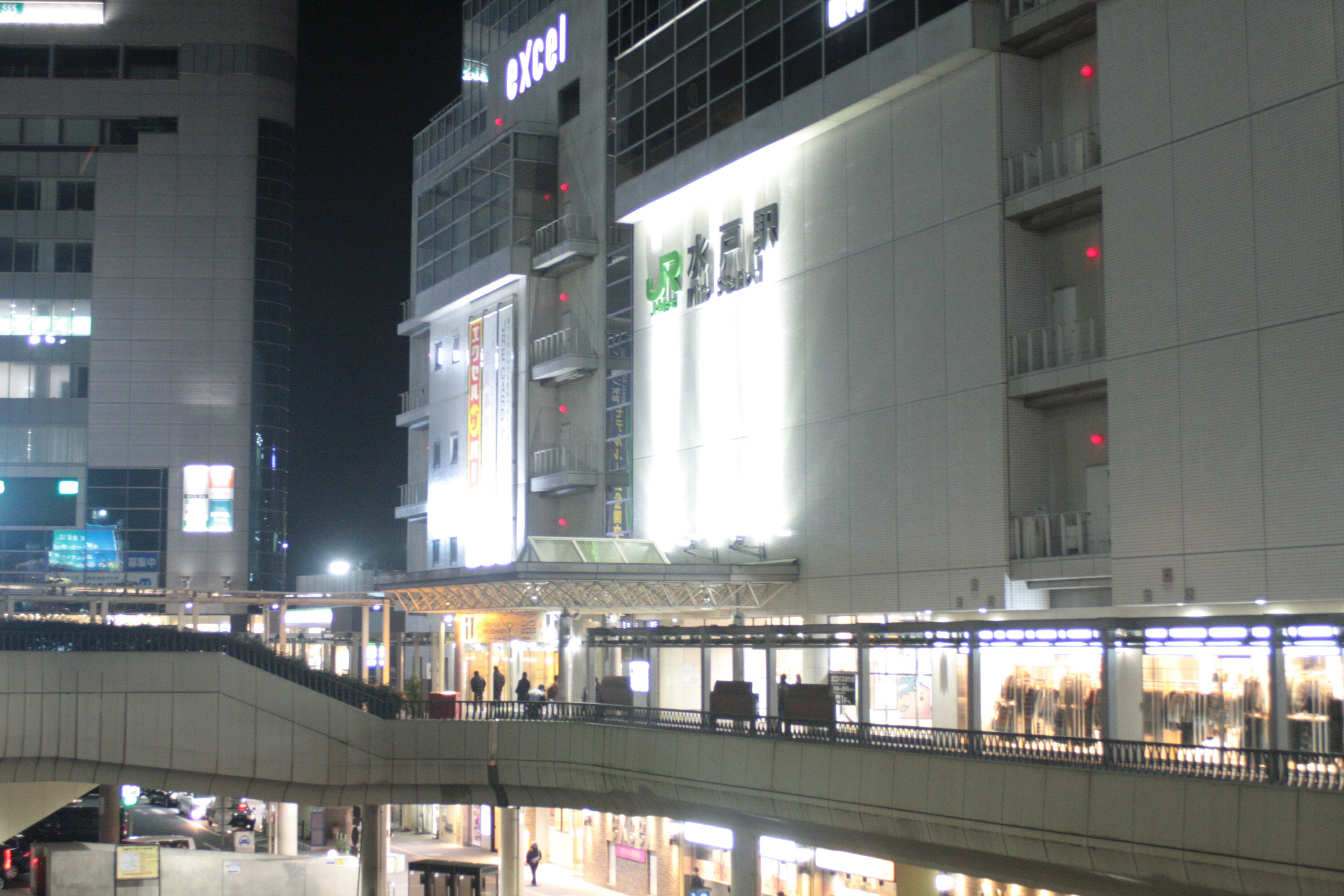 Exterior of a commercial building at night with bright signage