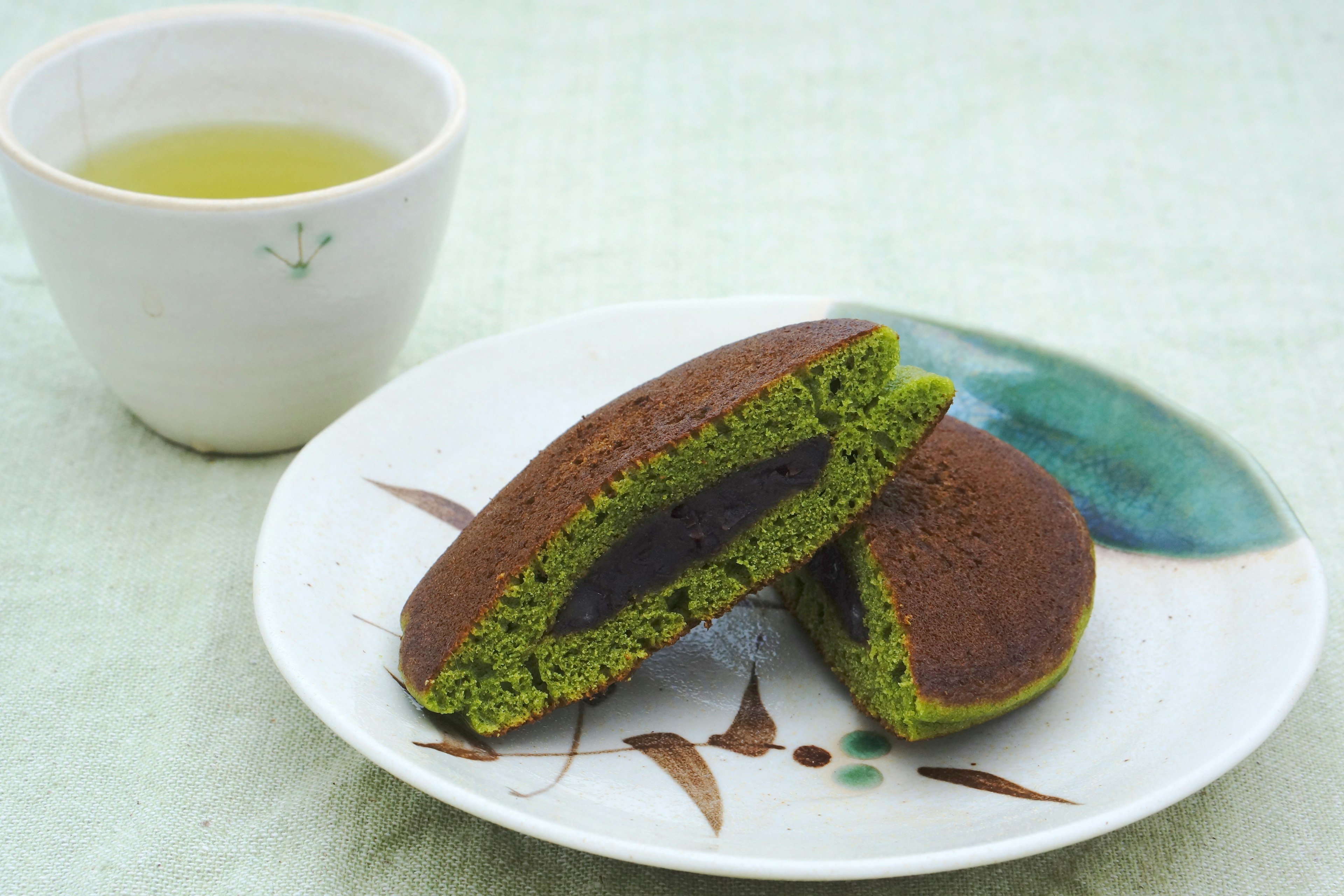 Japanische Süßigkeiten mit Matcha und roten Bohnen, serviert mit grünem Tee