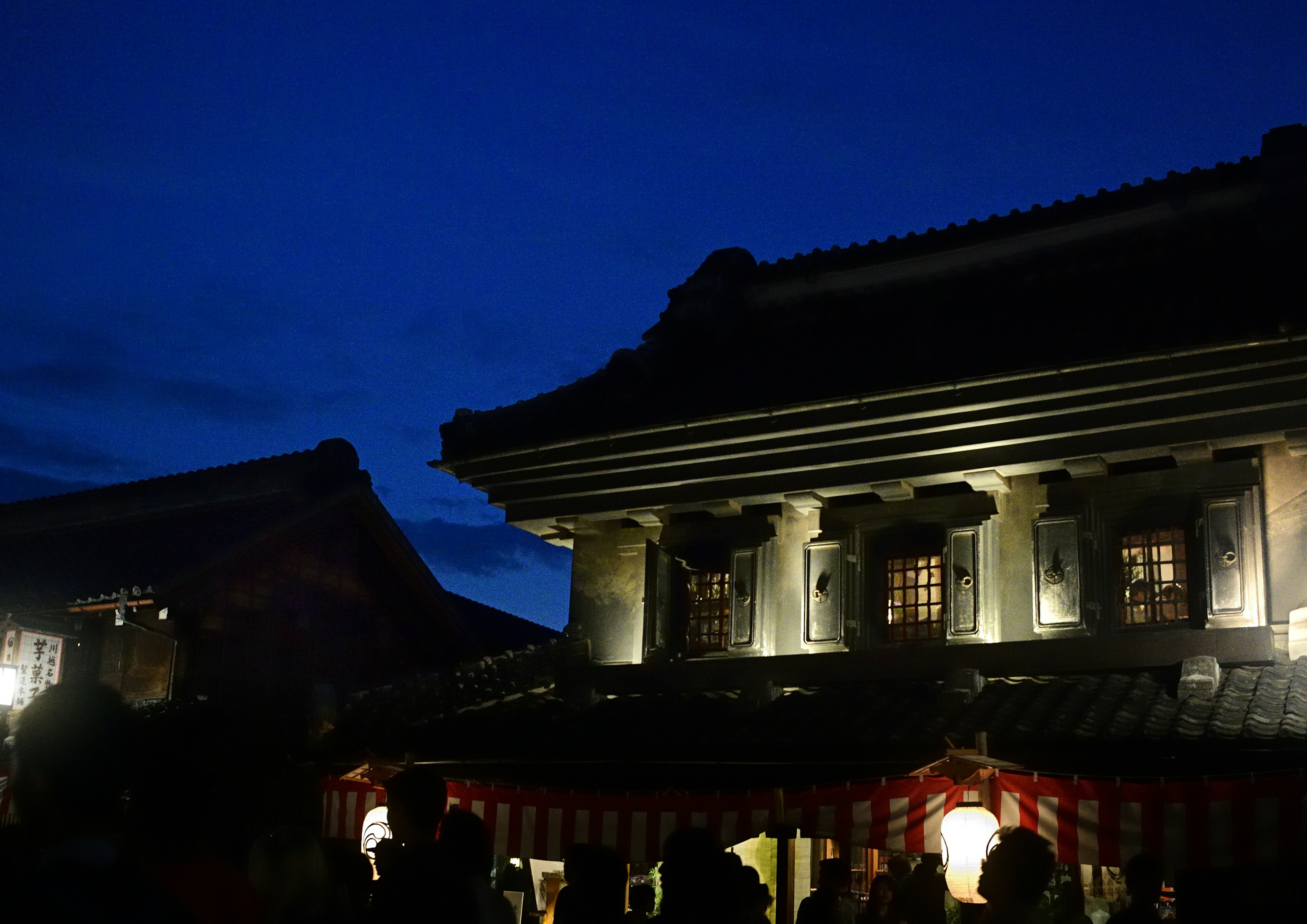 Traditionelles Gebäude unter einem blauen Nachthimmel beleuchtet