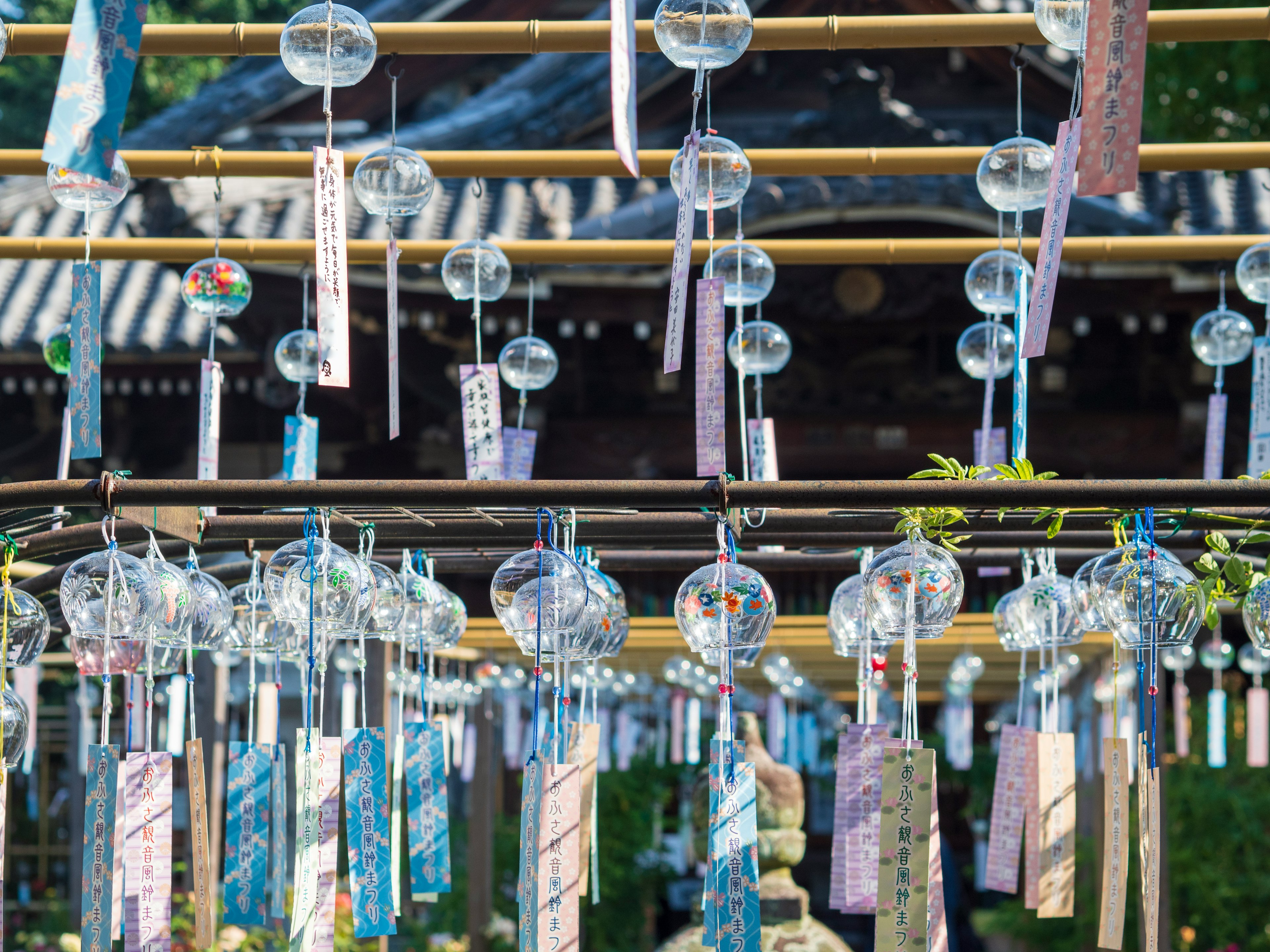 Image de cloches éoliennes et de tanzaku colorés suspendus à une structure en bambou