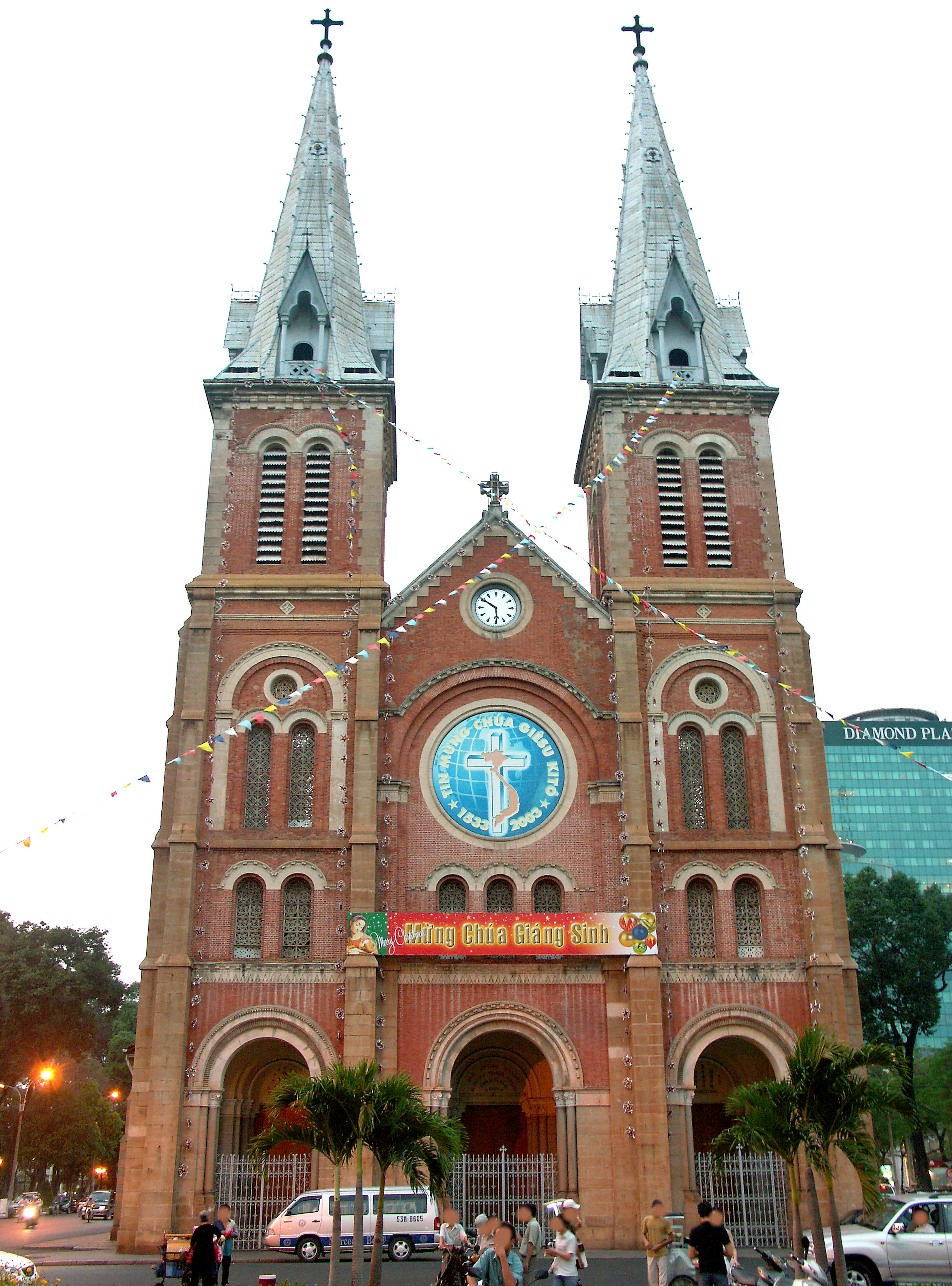 Red brick church with two spires and a large blue window