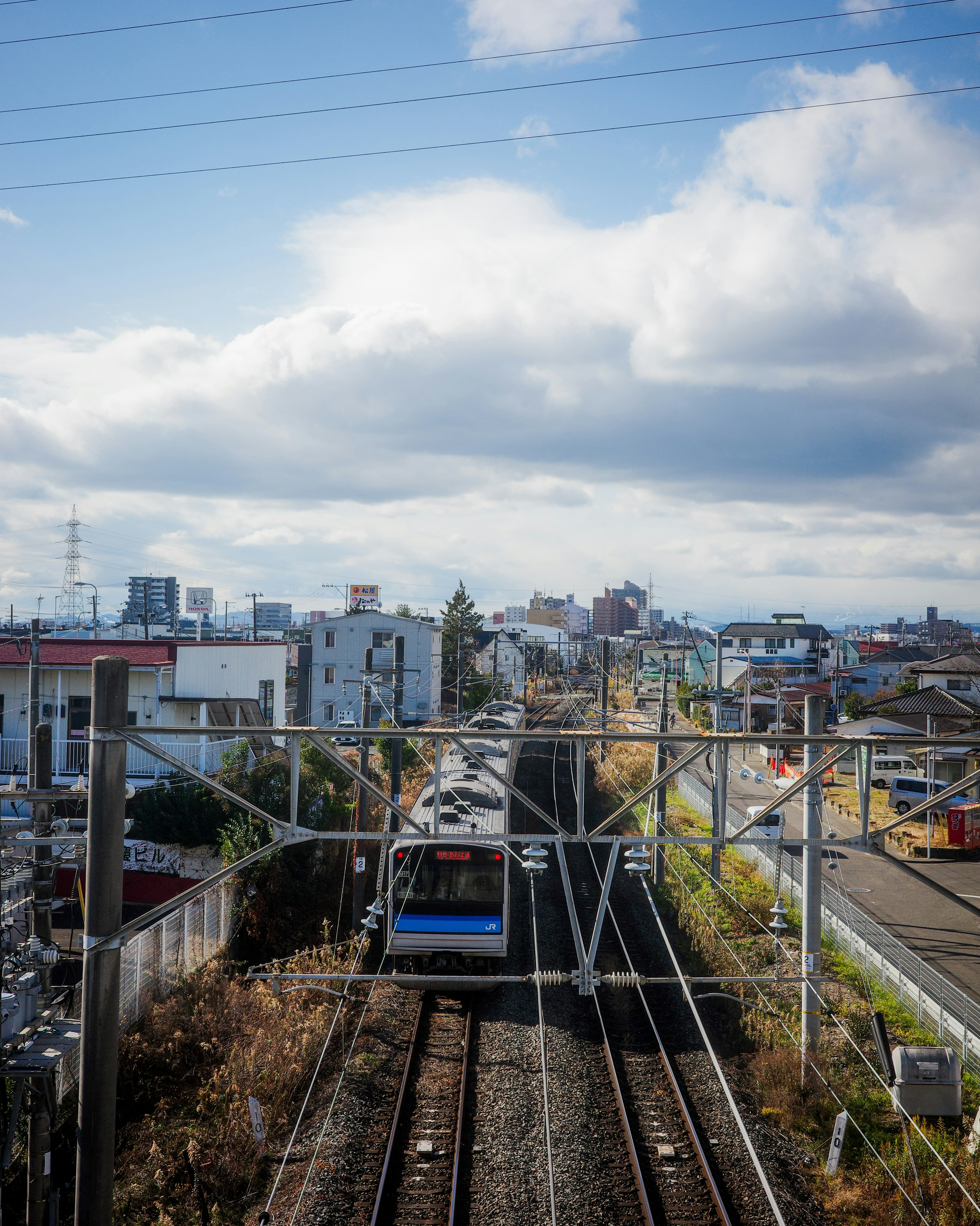 Blue train traveling along tracks in an urban landscape