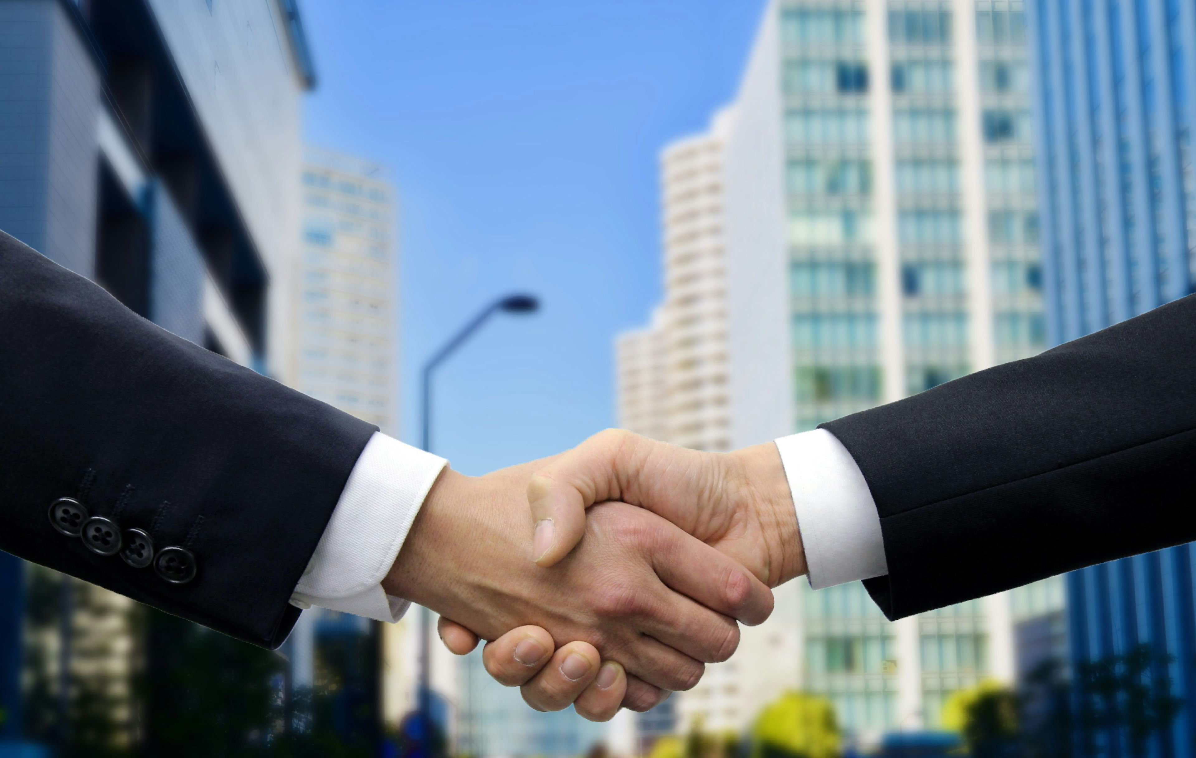 Businessmen shaking hands with skyscrapers in the background