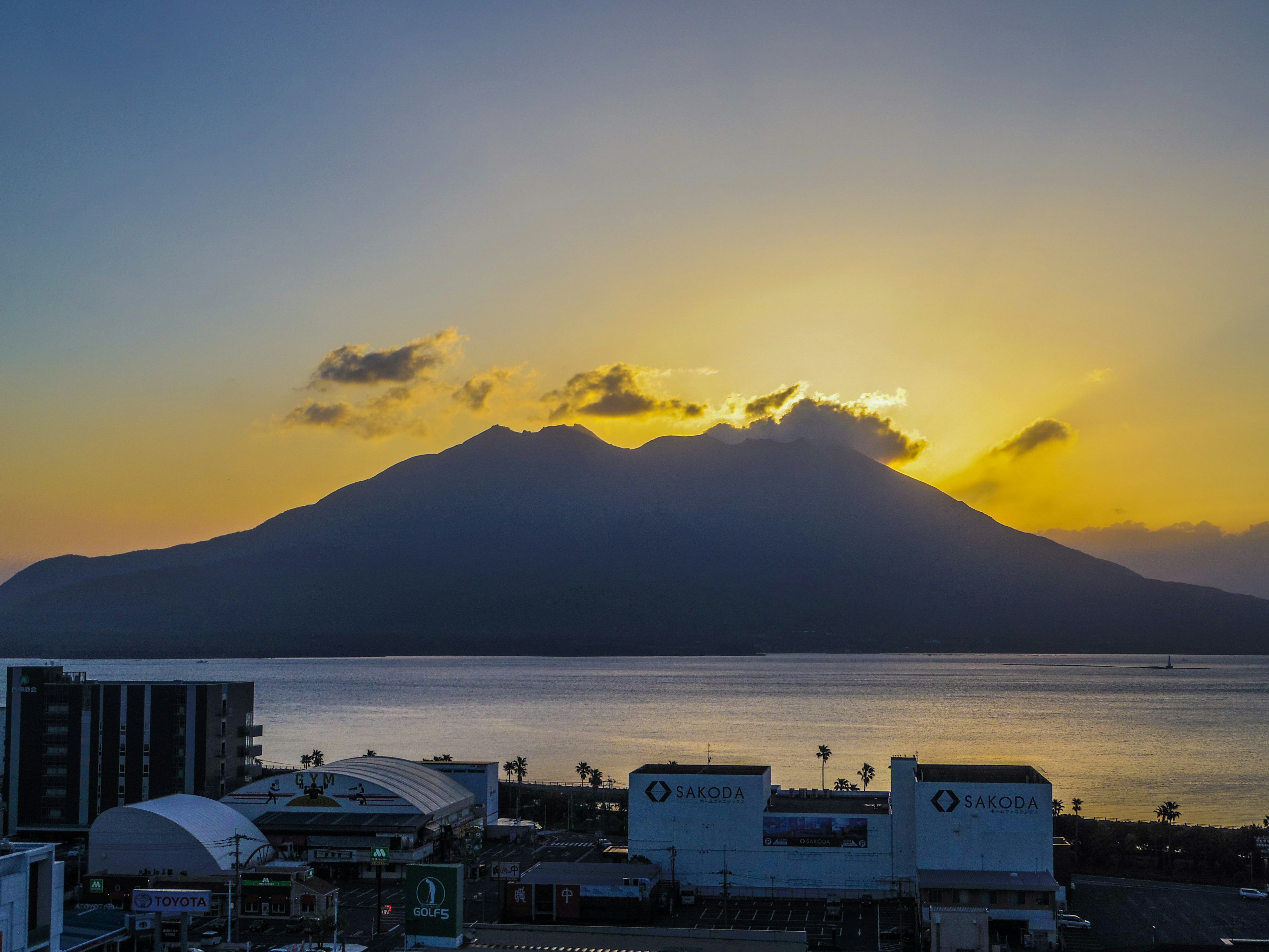 Silhouette d'une montagne au coucher de soleil et vue sur une mer calme