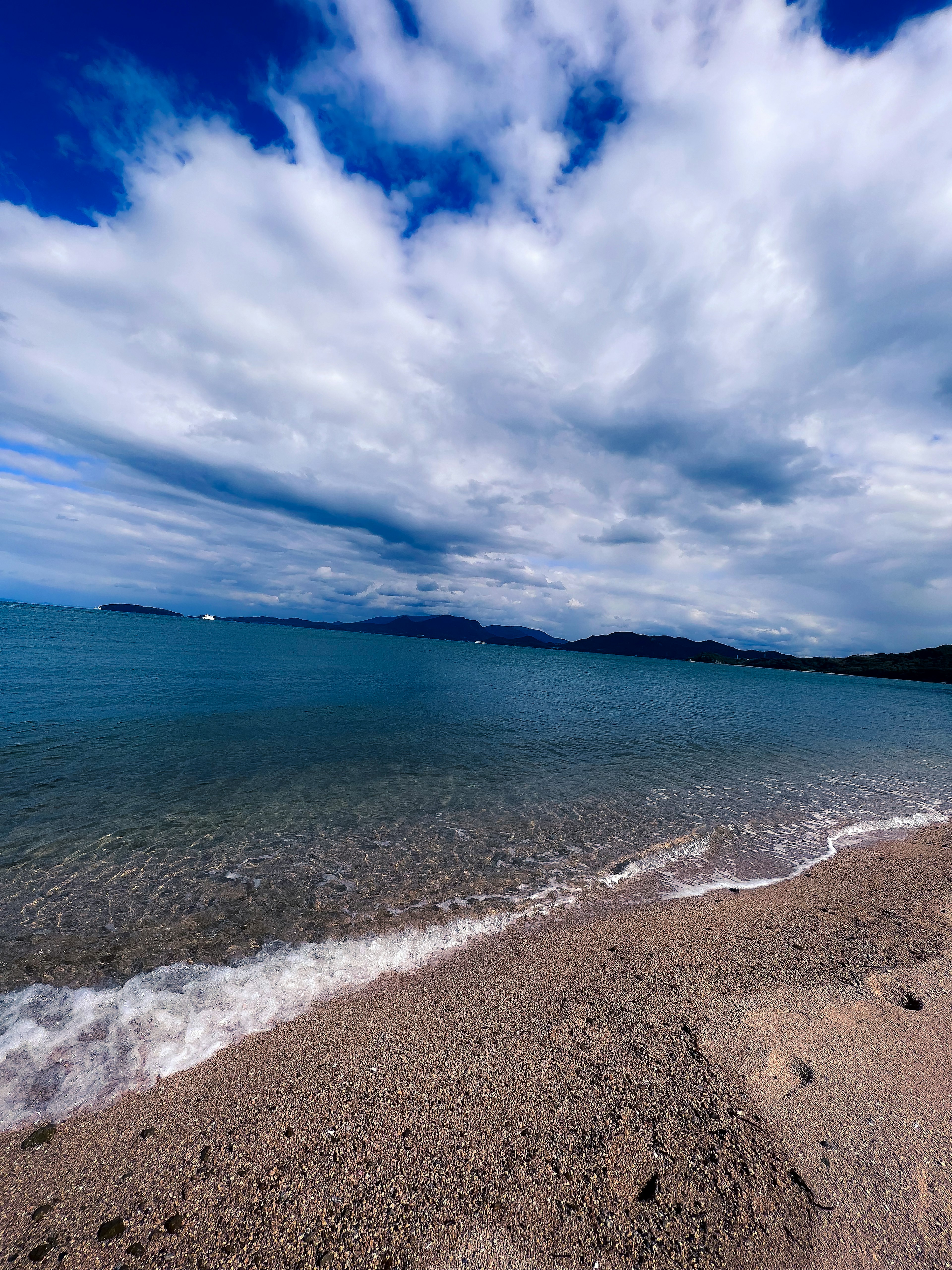 藍色海洋和沙灘的風景，天空多雲