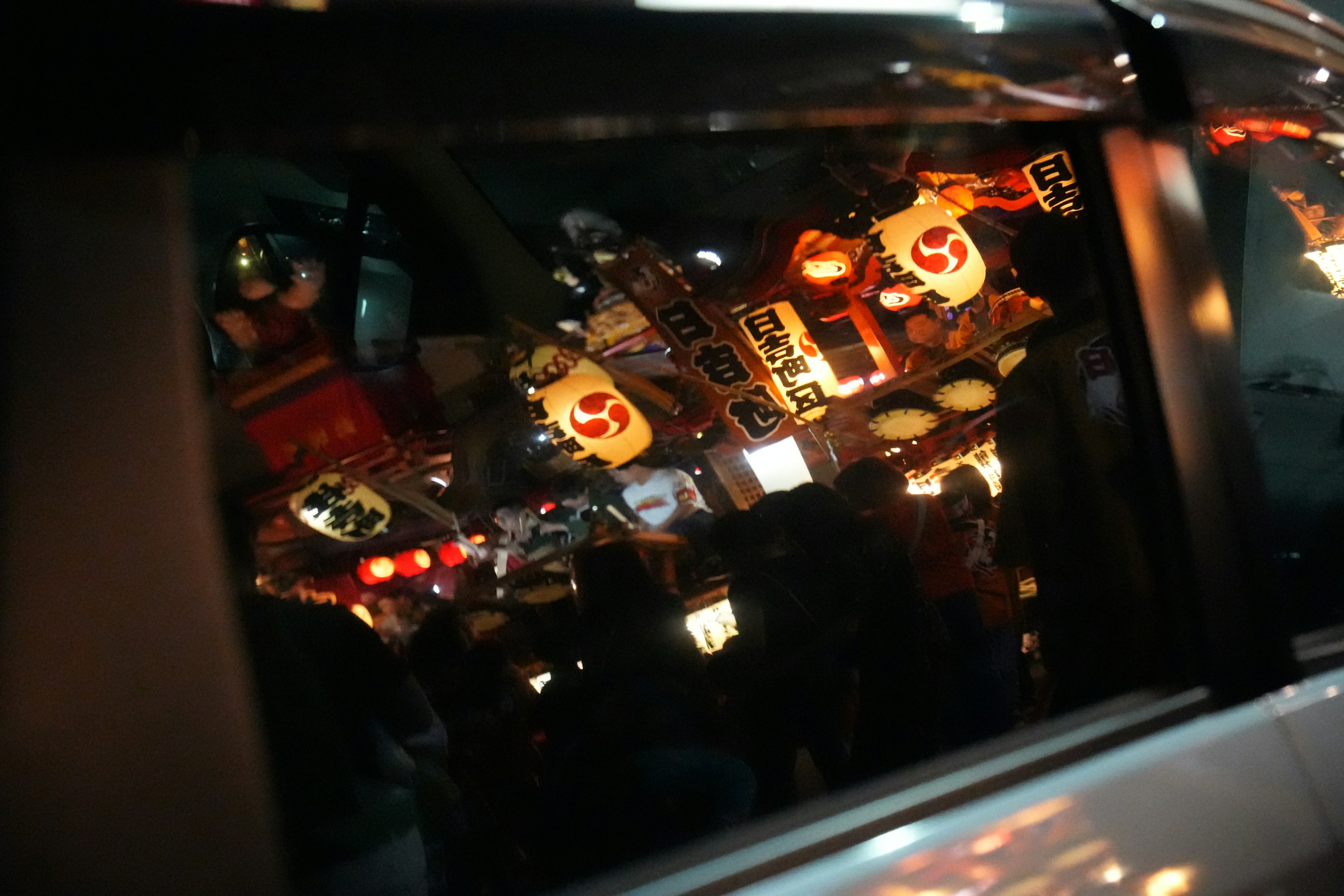 Reflejo de letreros de restaurantes coreanos y luces de neón en una ventana de coche