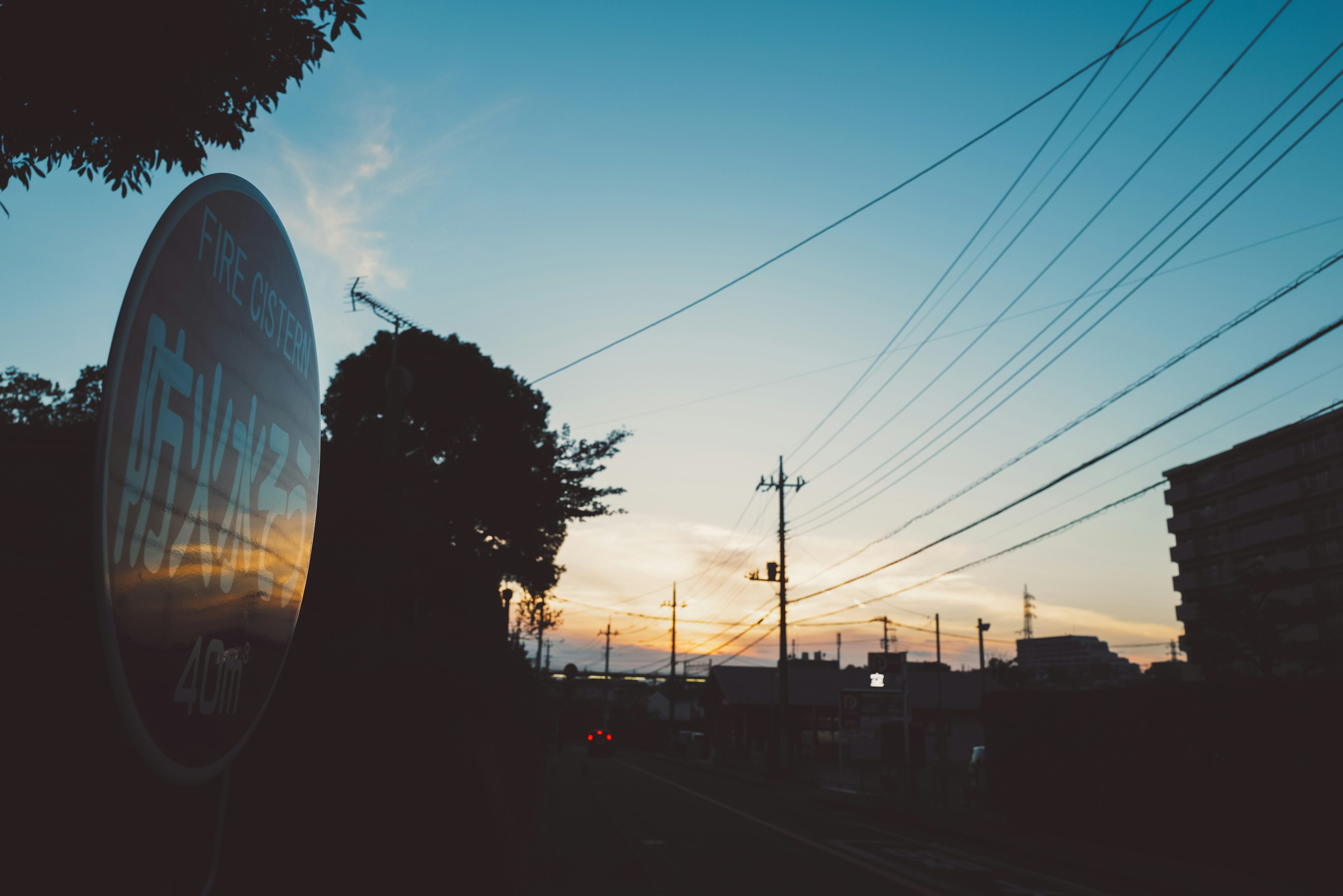 夕焼けを背景にした街の風景と電線