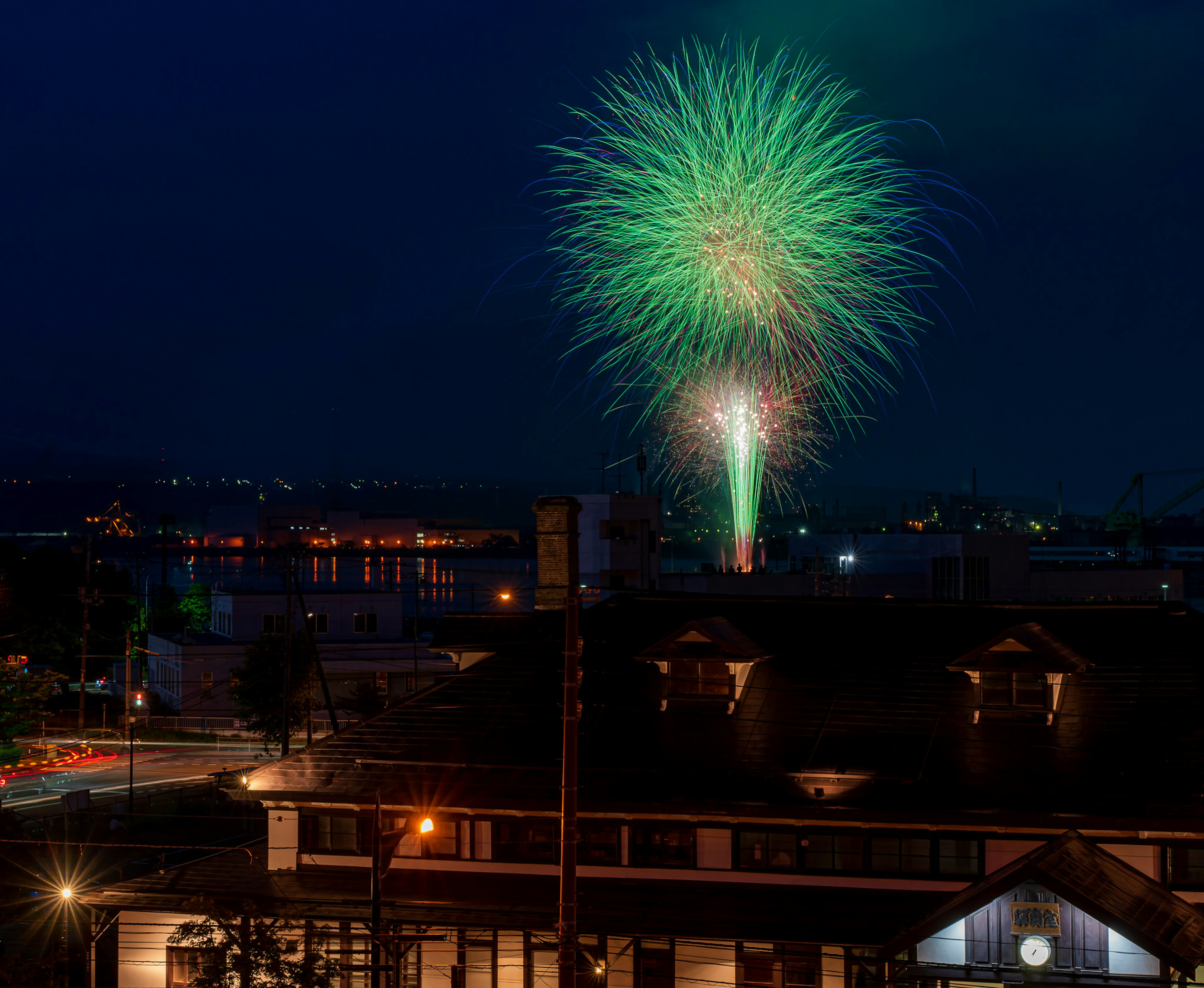 夜空に緑色の花火が咲く光景