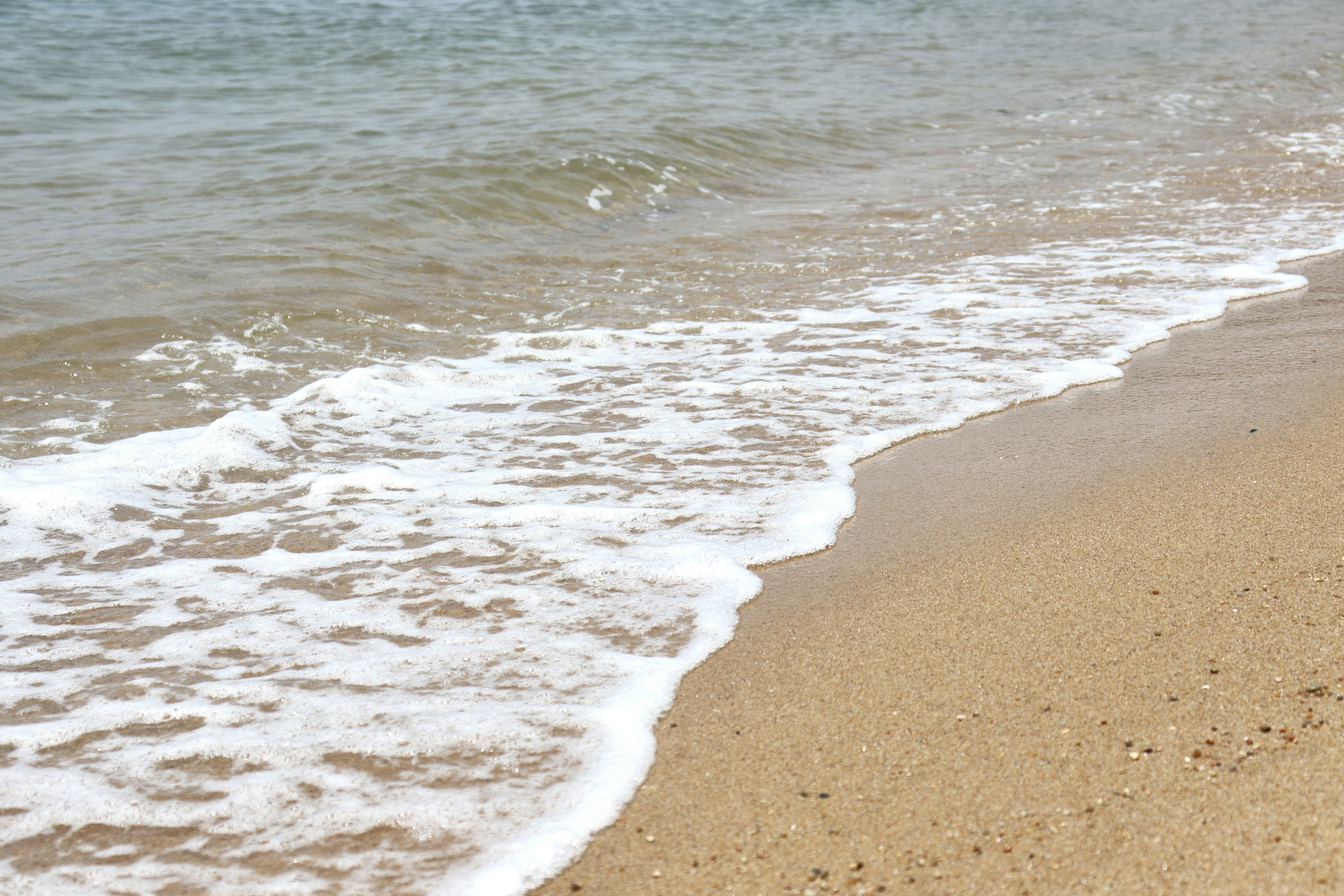 Onde calme che si infrangono su una spiaggia di sabbia