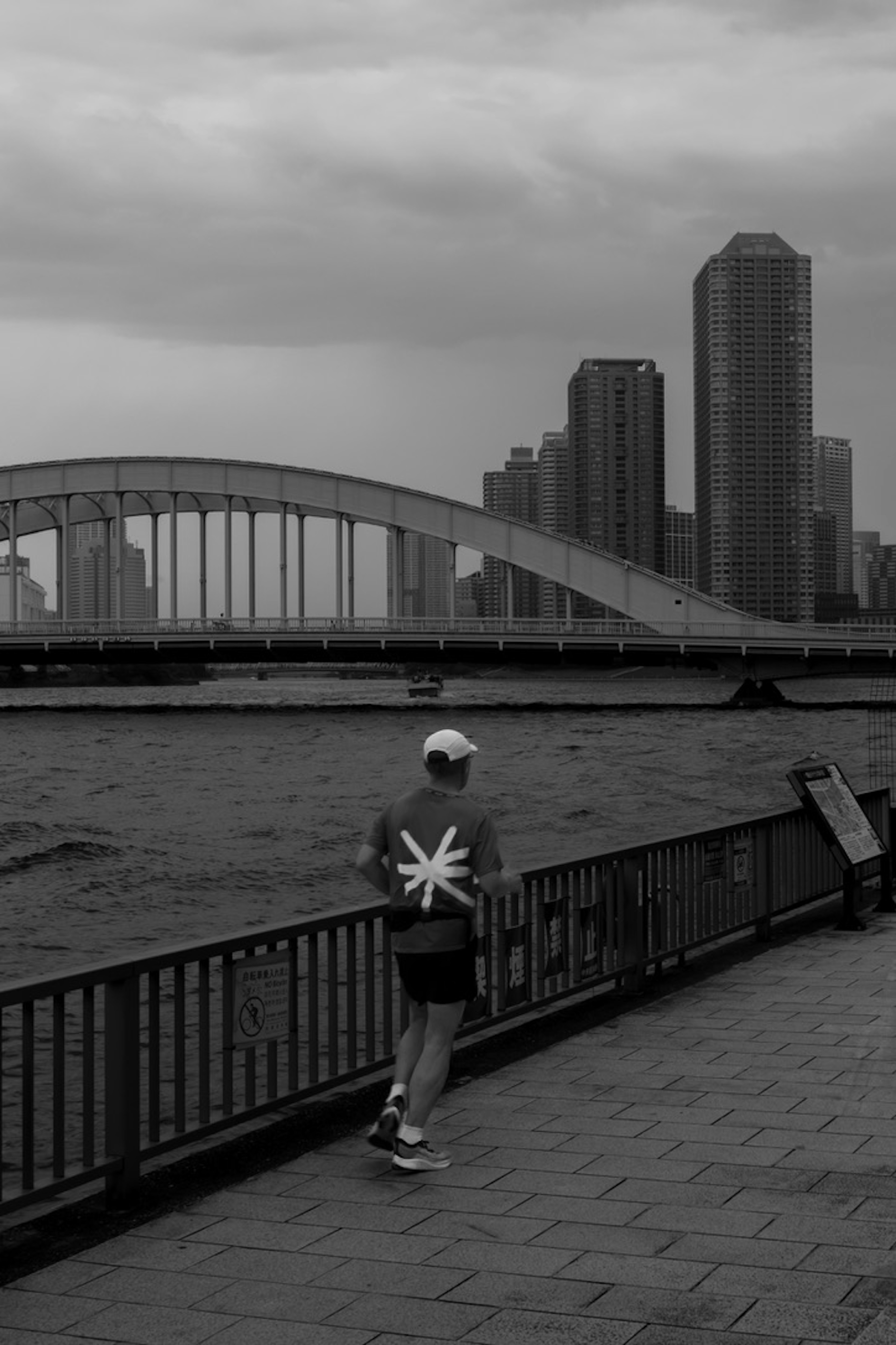 黒白の風景でランニングする人物と都市の背景