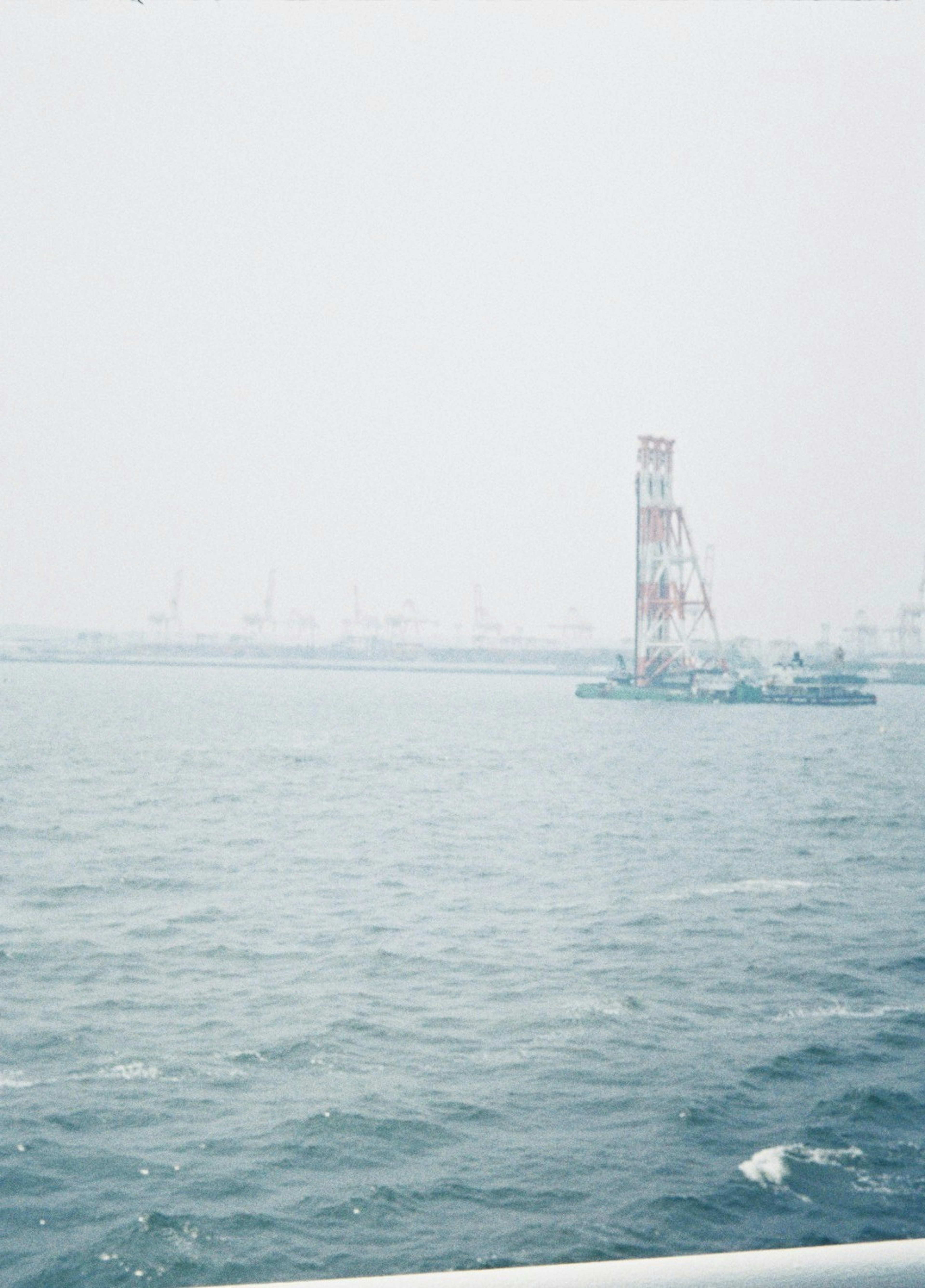 海上に立つ赤白の灯台と霧の中の背景