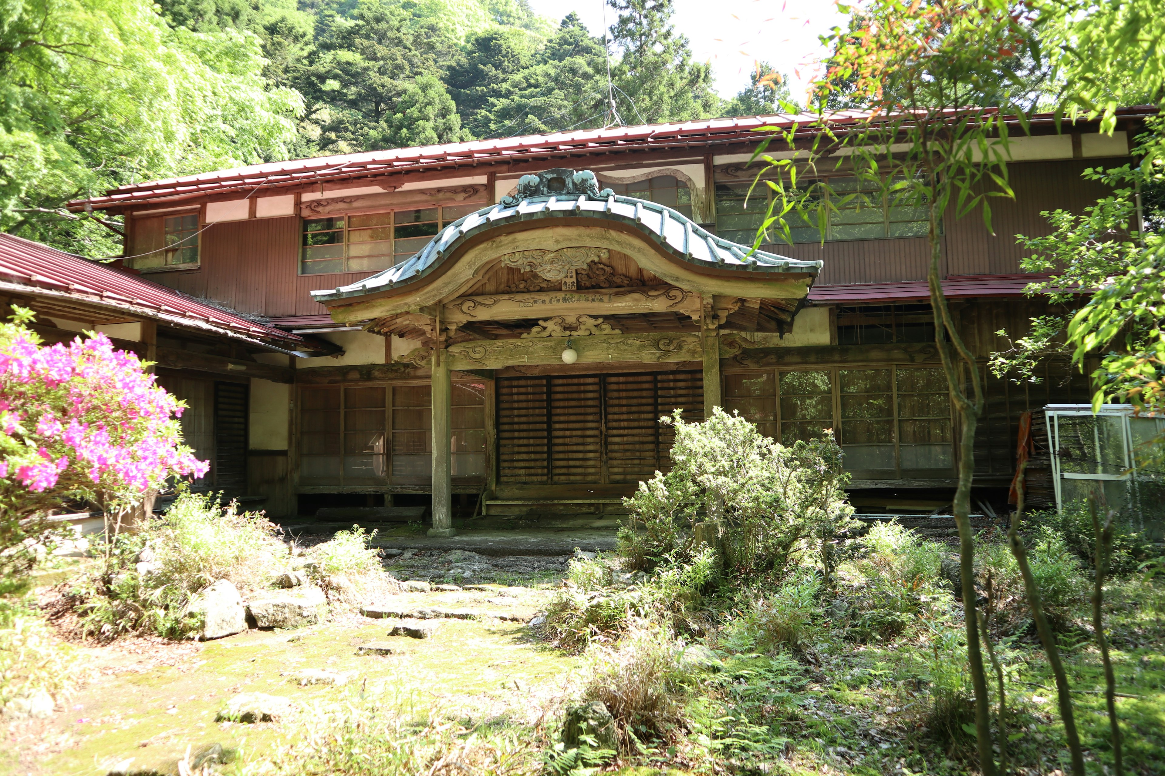 Rumah tradisional Jepang dan pemandangan taman dikelilingi tanaman dan bunga