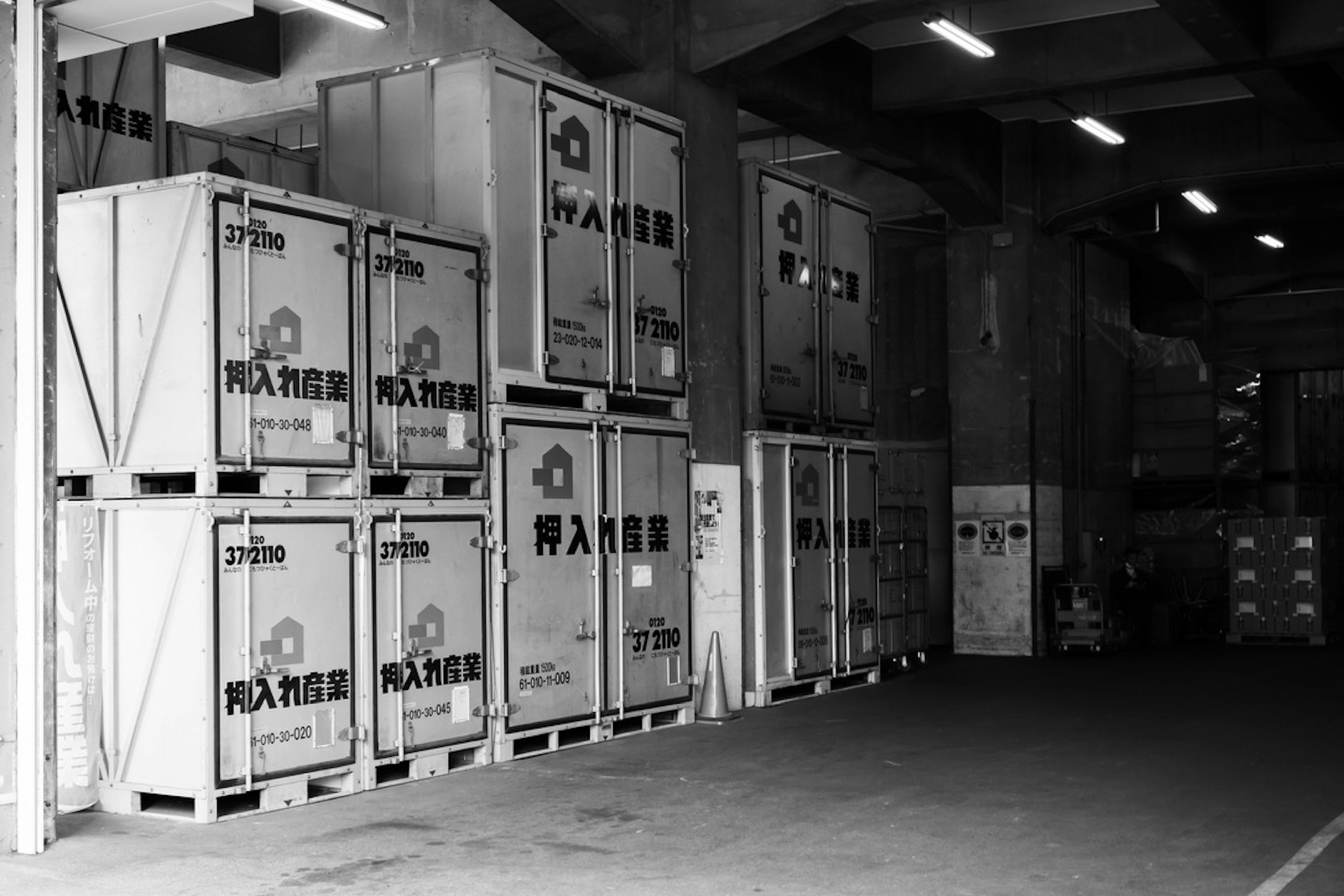 Scene of stacked white containers inside a warehouse