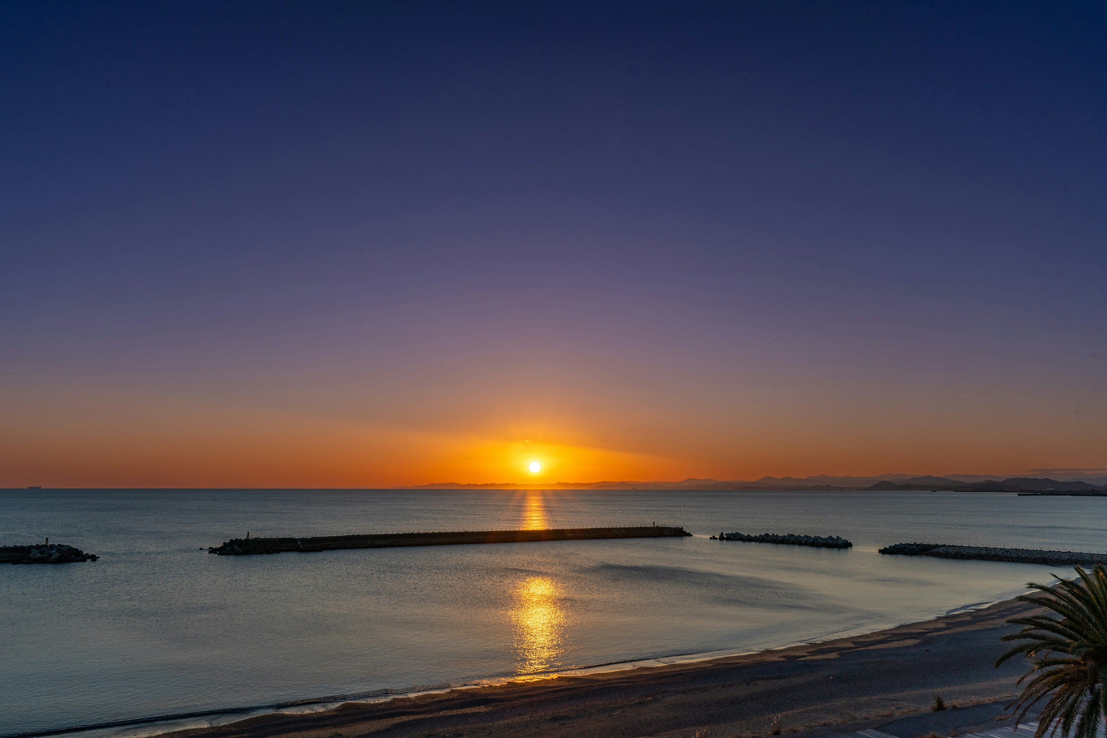 美しい海岸線に沈む夕日と穏やかな海の景色