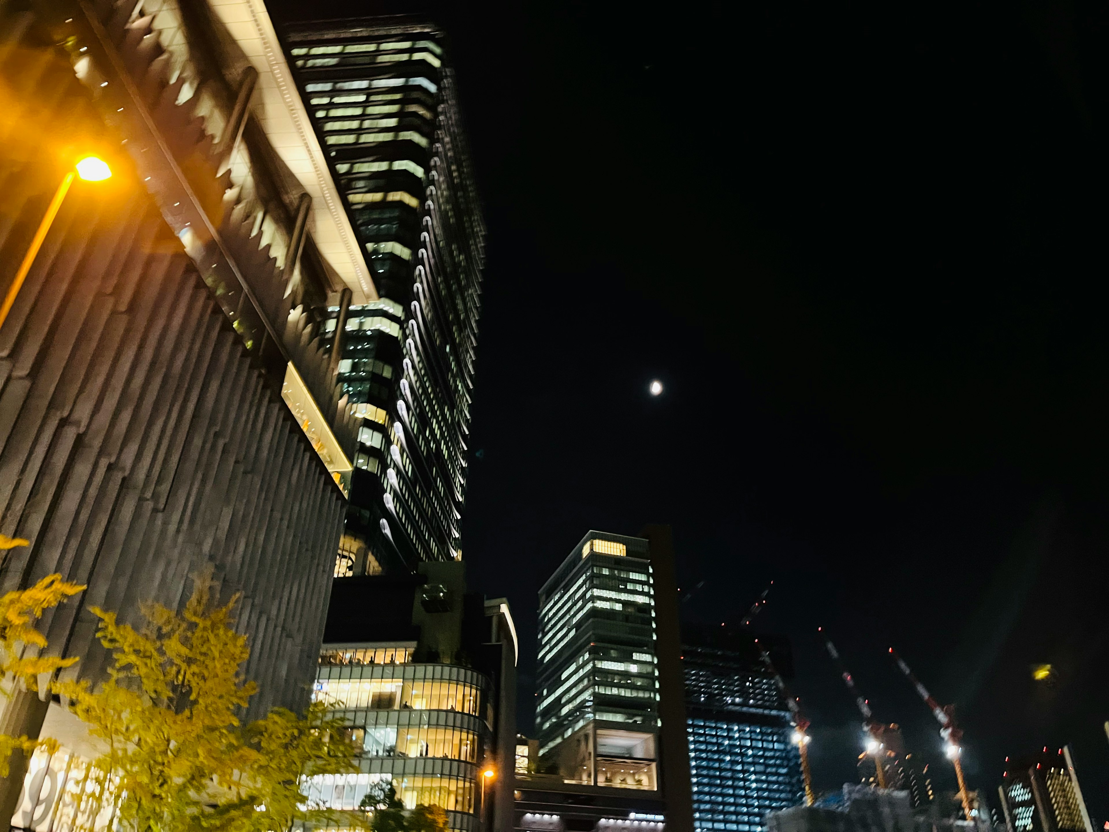 夜の都市景観と月明かりの風景ビルの明かりが輝いている