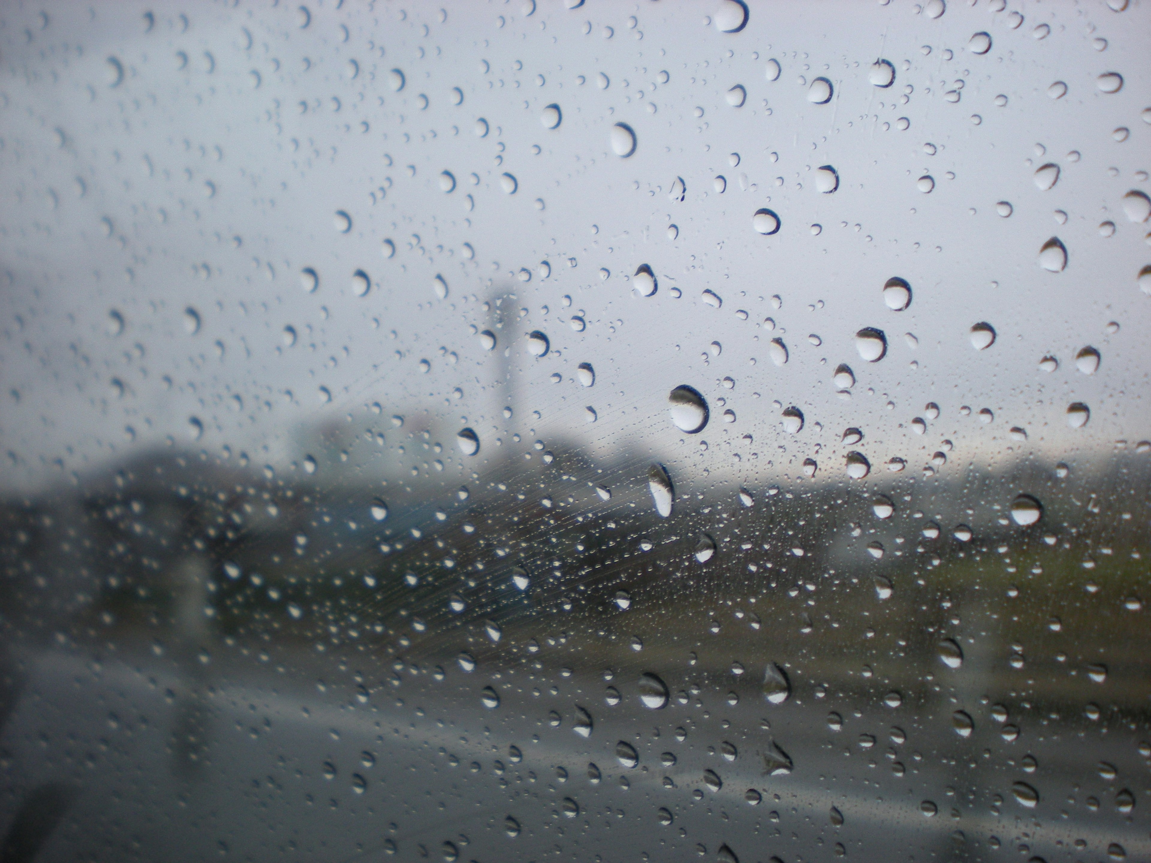 Vista a través de una ventana lluviosa con gotas de agua