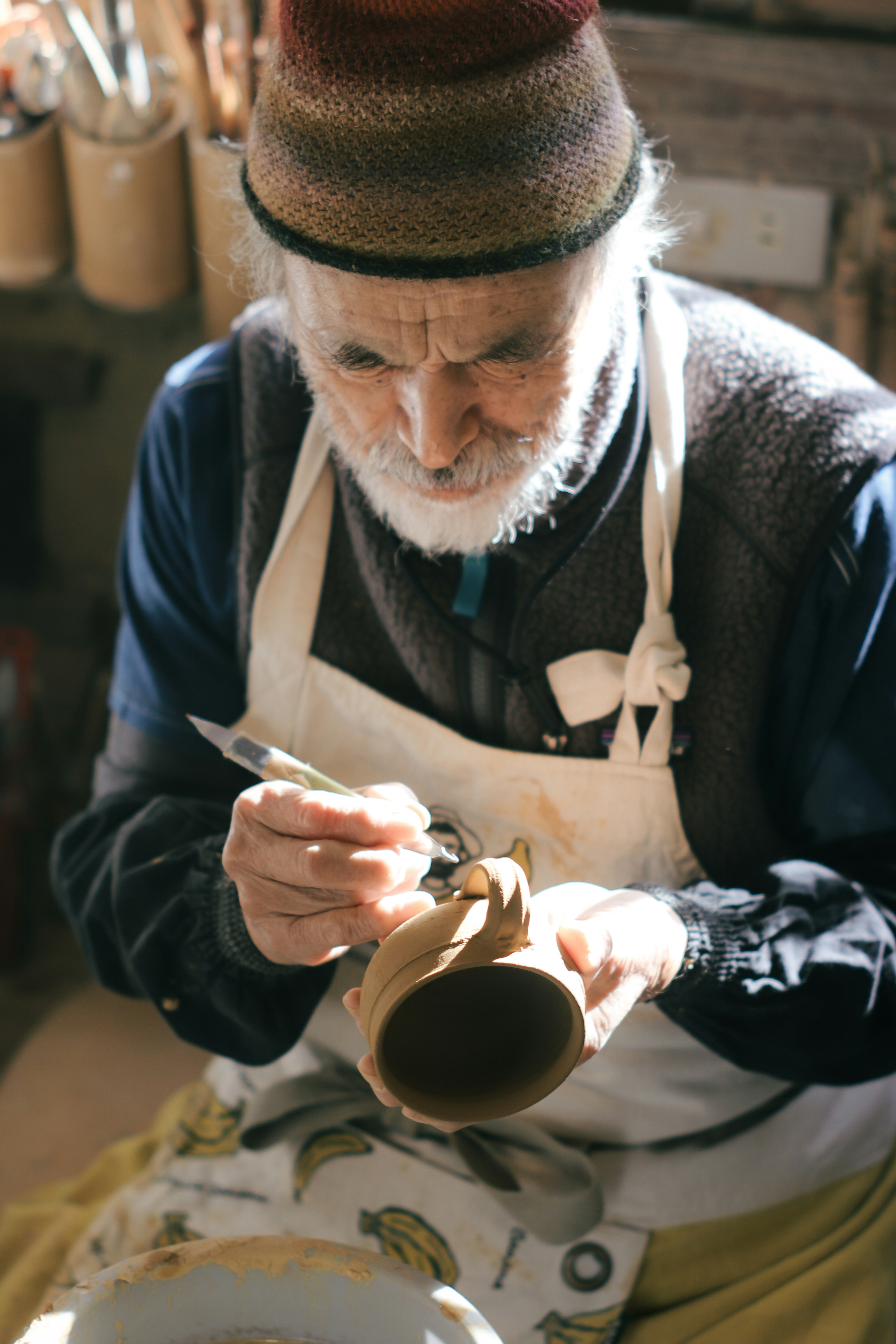 Alter Handwerker malt einen Keramiktopf