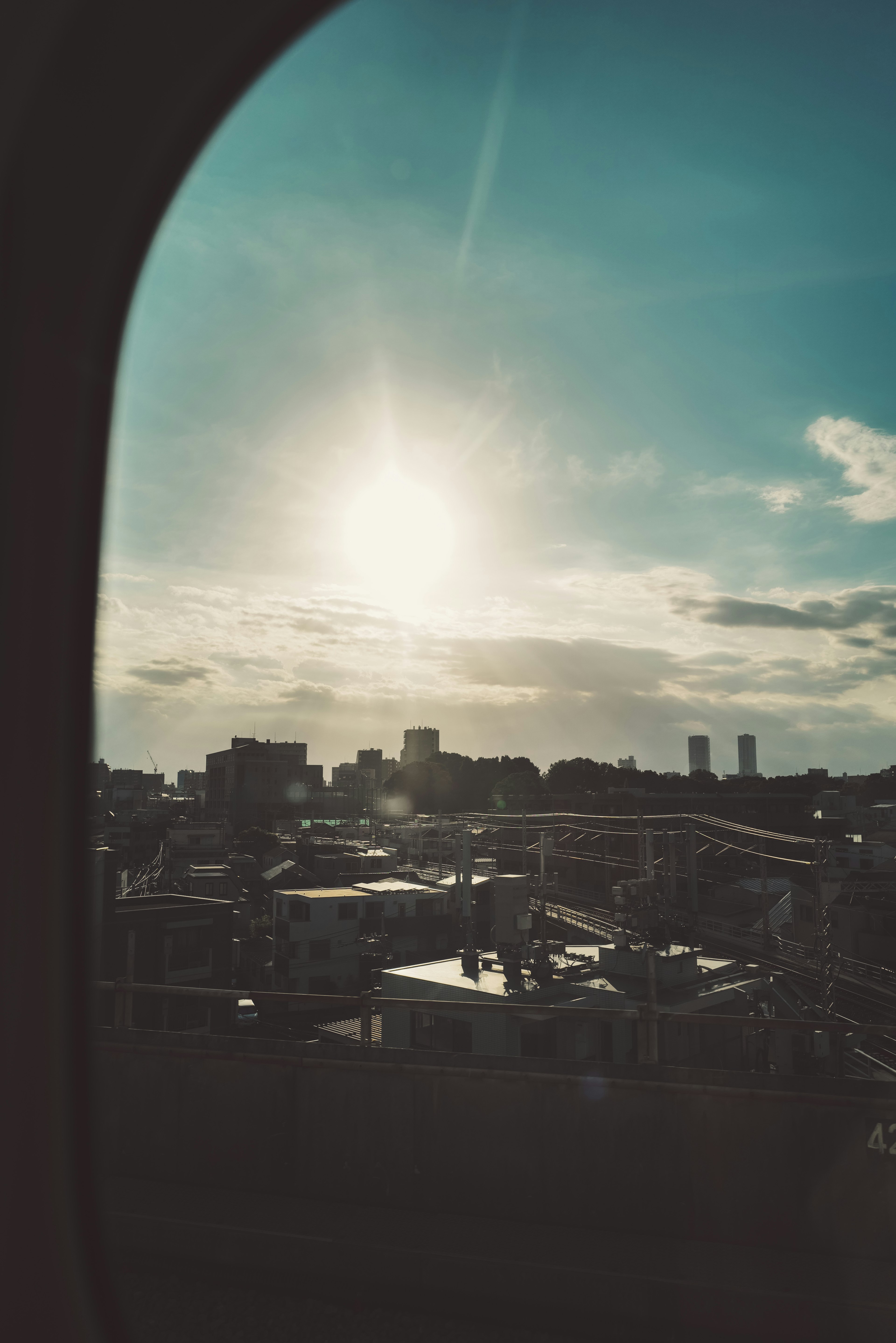 窓から見える都市の風景と太陽の光