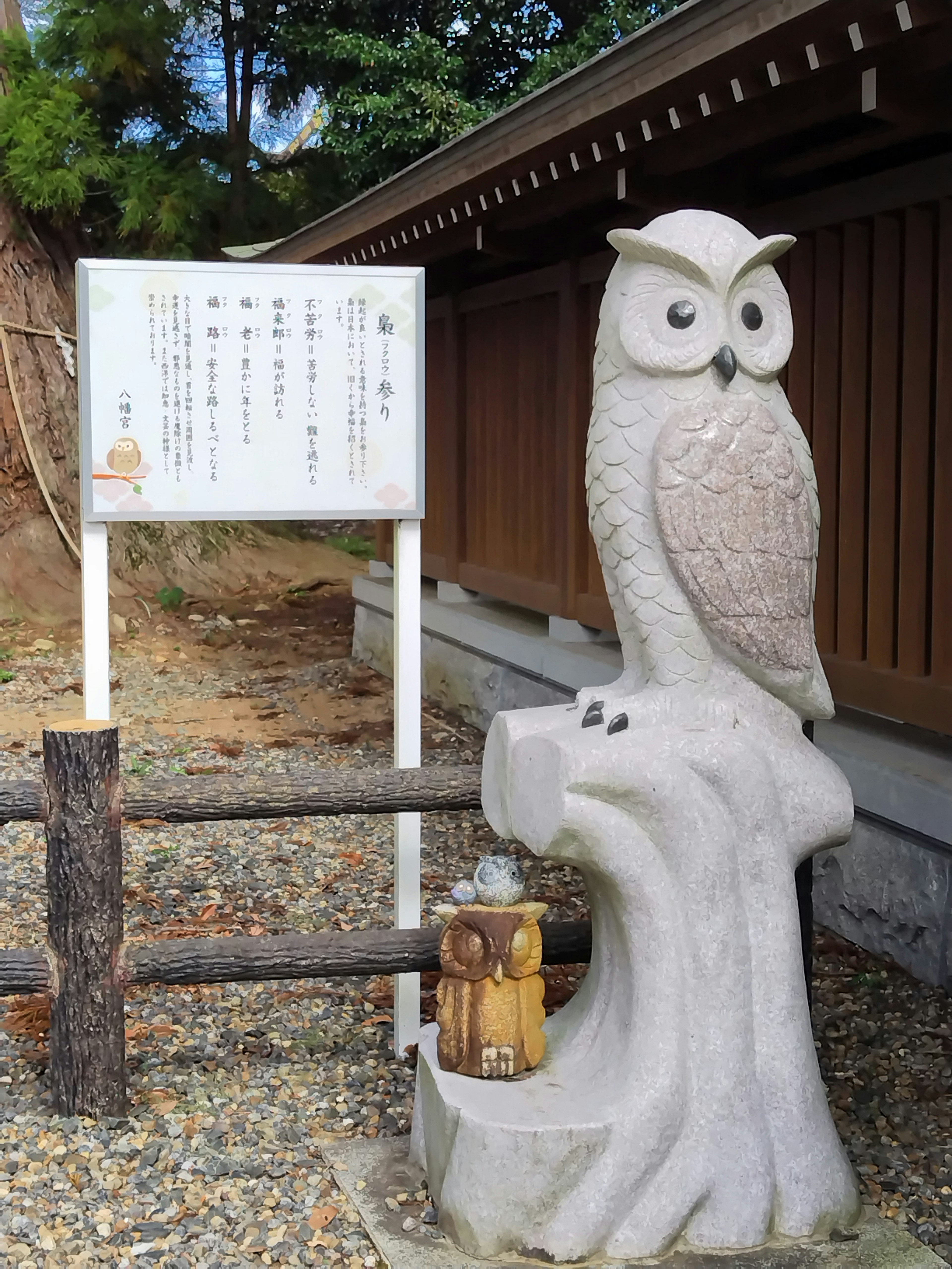 Sculpture de hibou en pierre à côté d'un panneau d'information