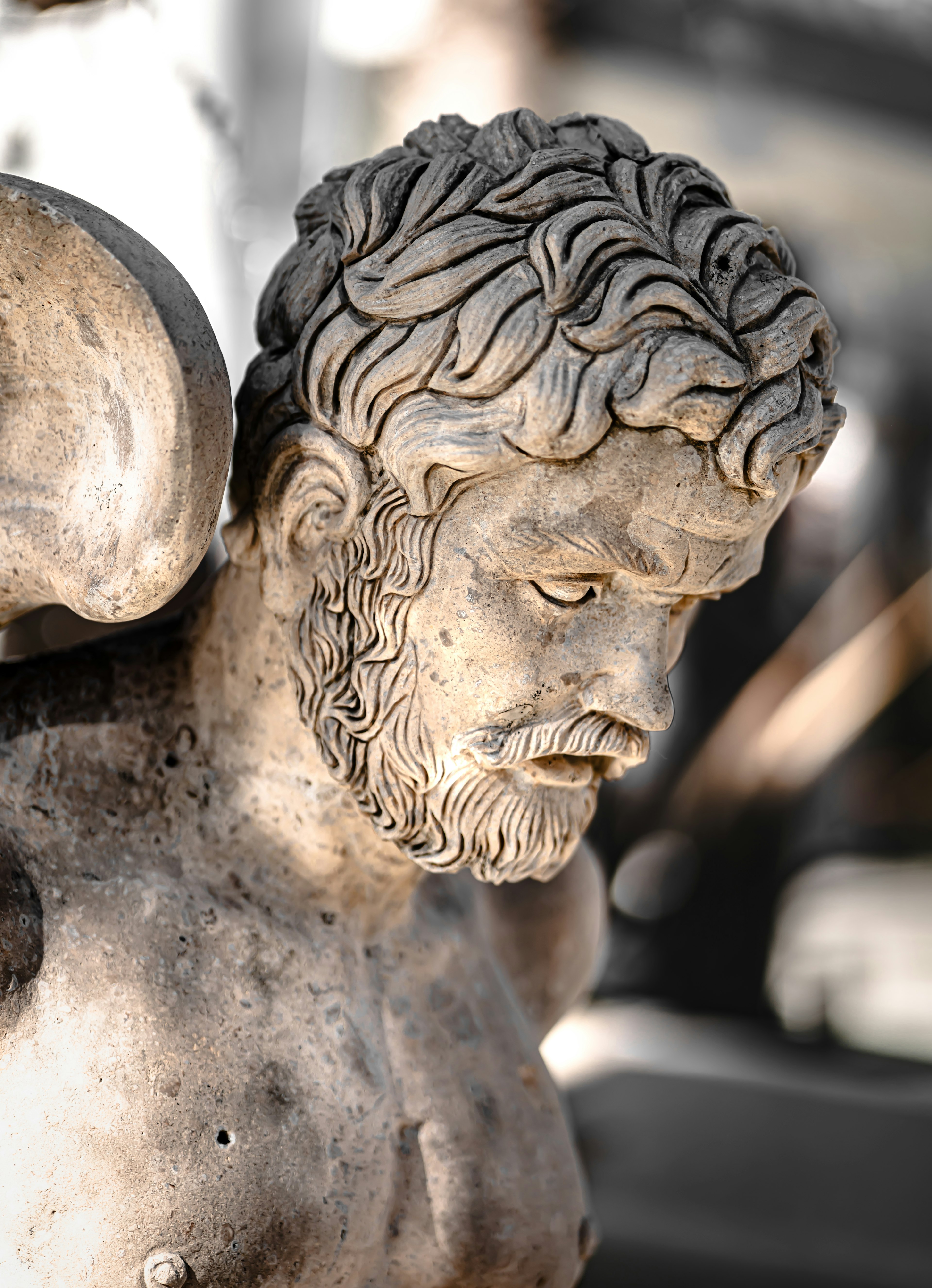 Close-up of a male sculpture featuring intricately carved hair and beard