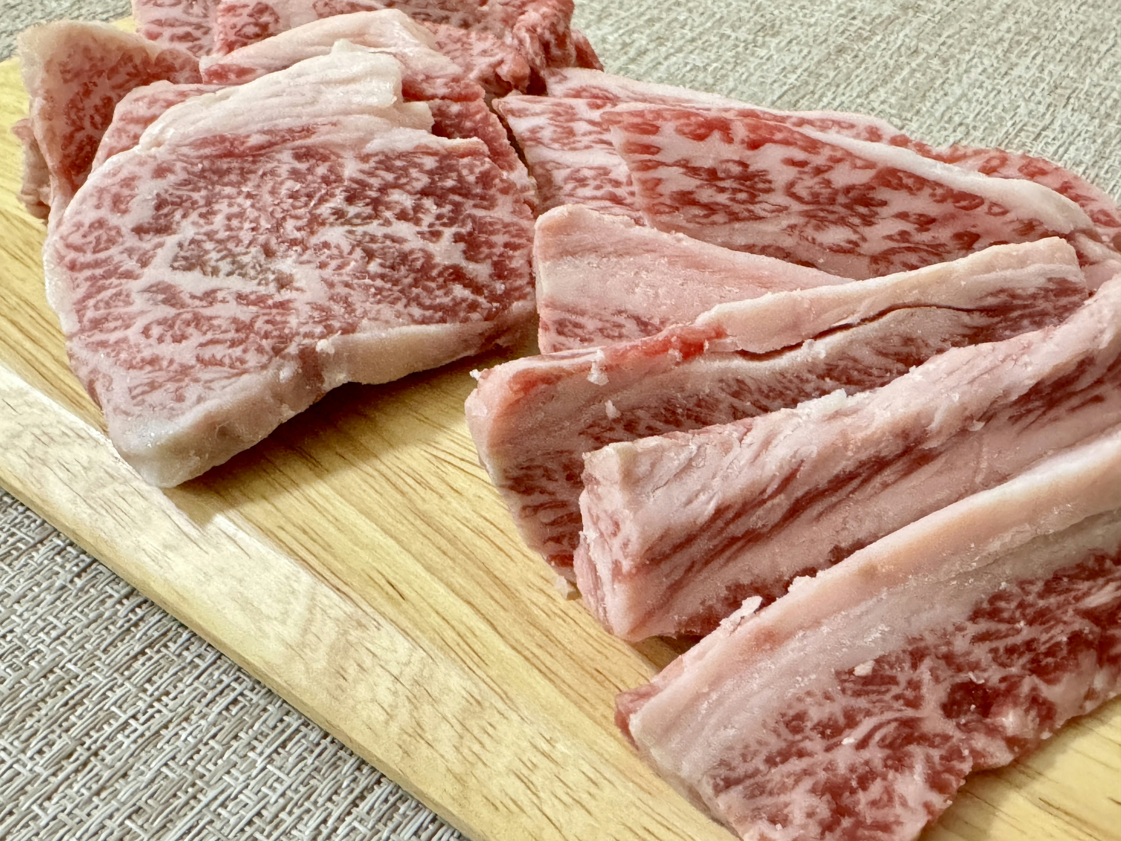 Beautiful marbled Wagyu beef arranged on a wooden cutting board