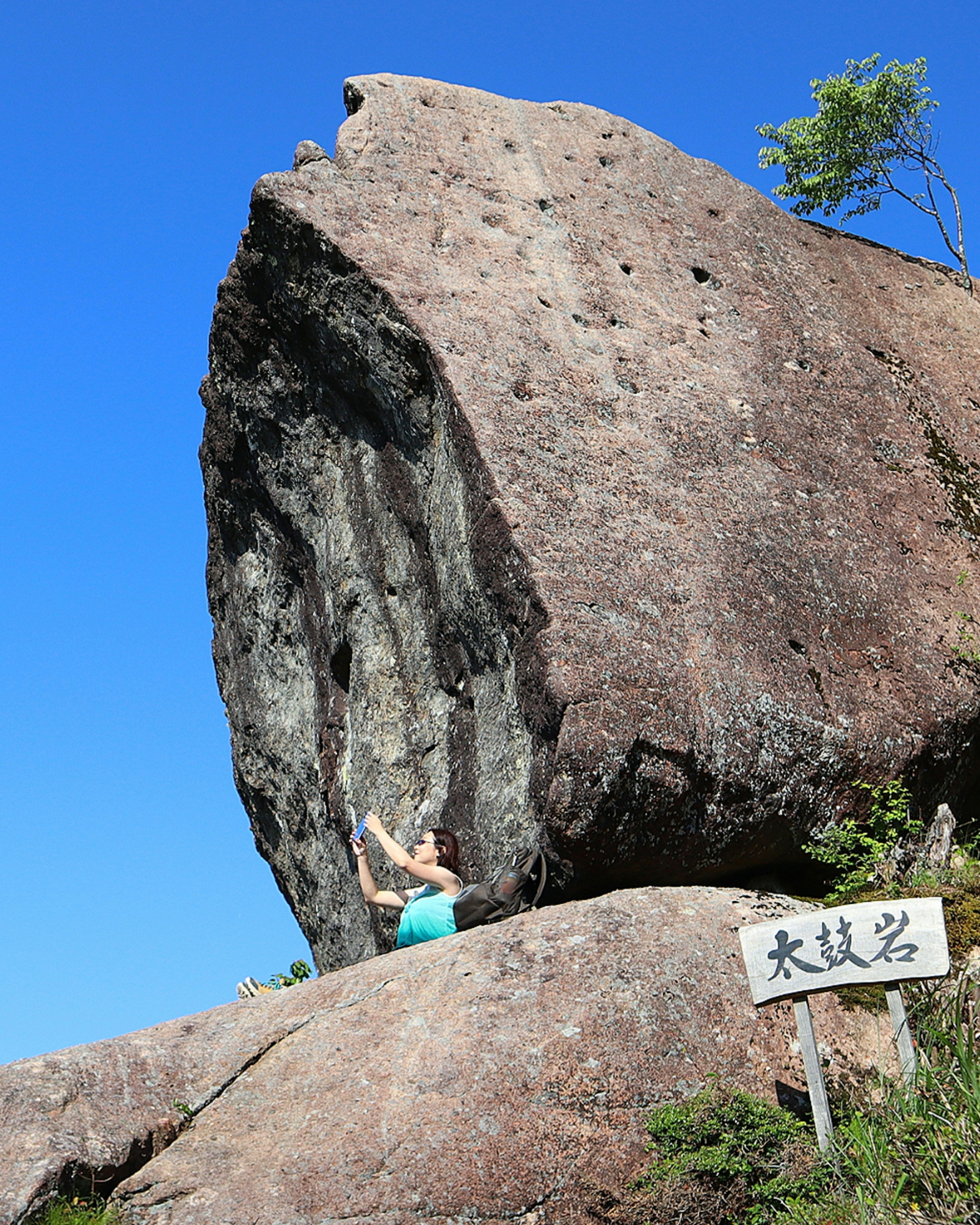 Person klettert vor einem großen Felsen unter blauem Himmel natürliche Landschaft