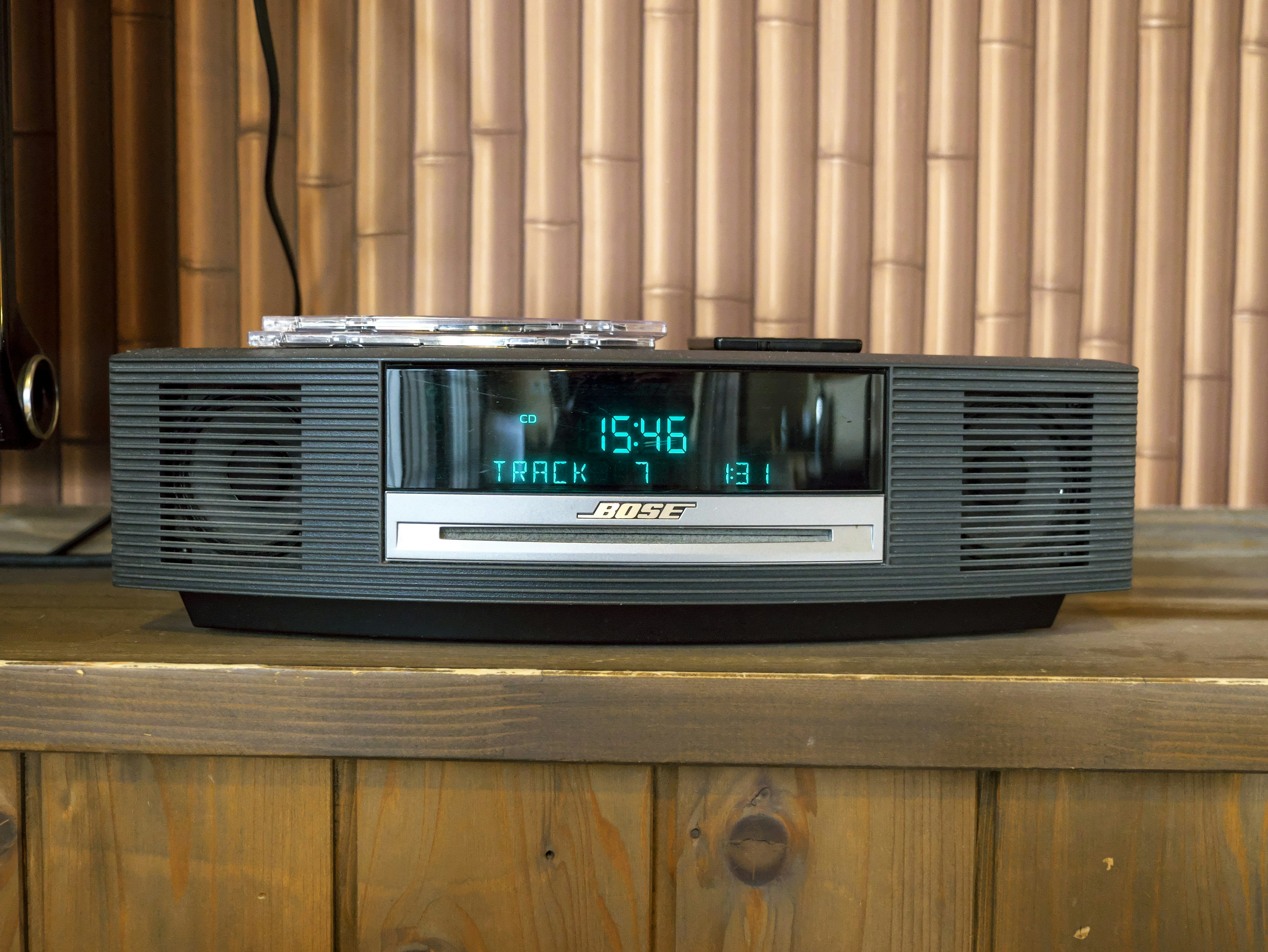 Bose music system placed on a wooden table digital display shows track number and time