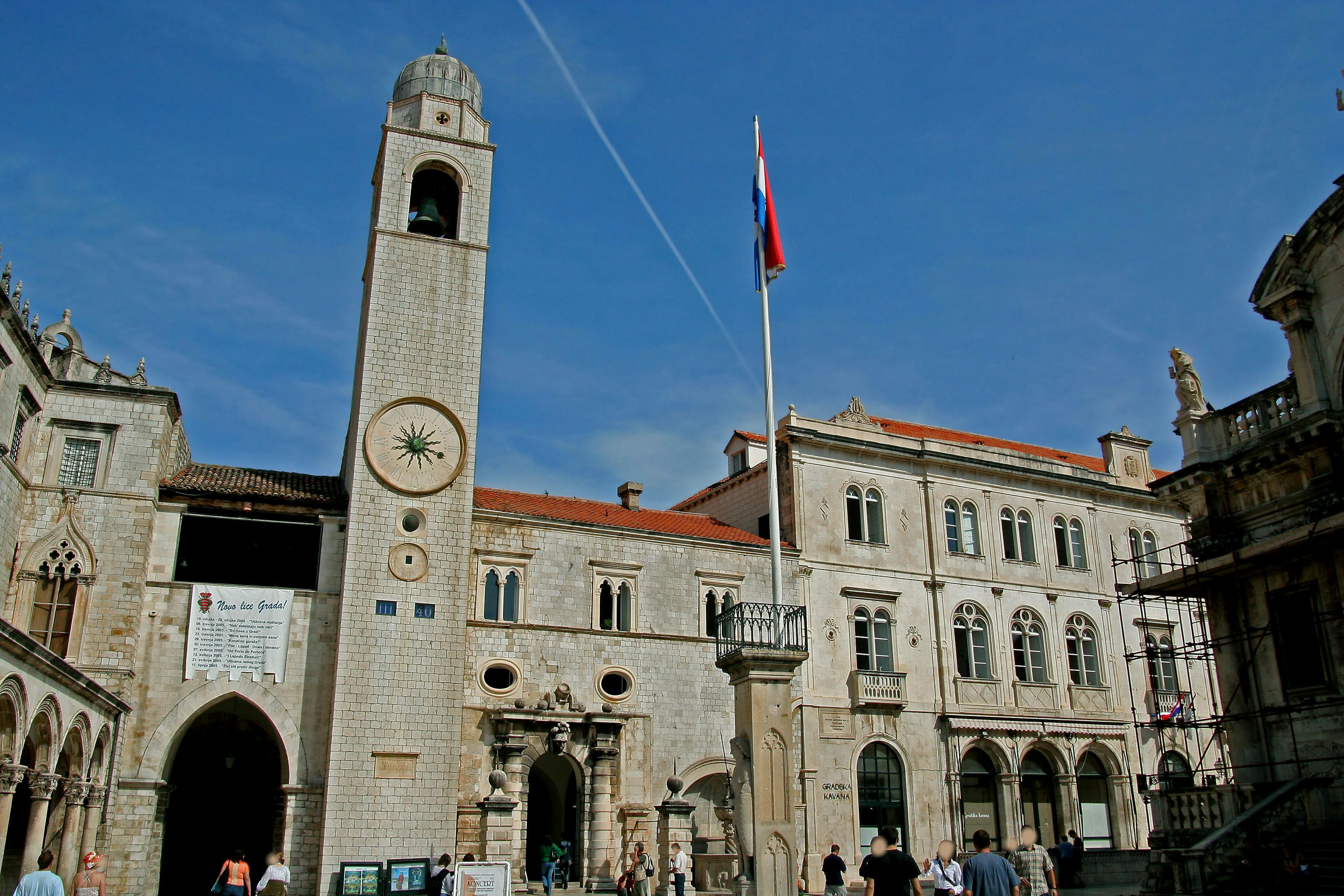 Alun-alun bersejarah di Dubrovnik dengan menara jam dan bendera