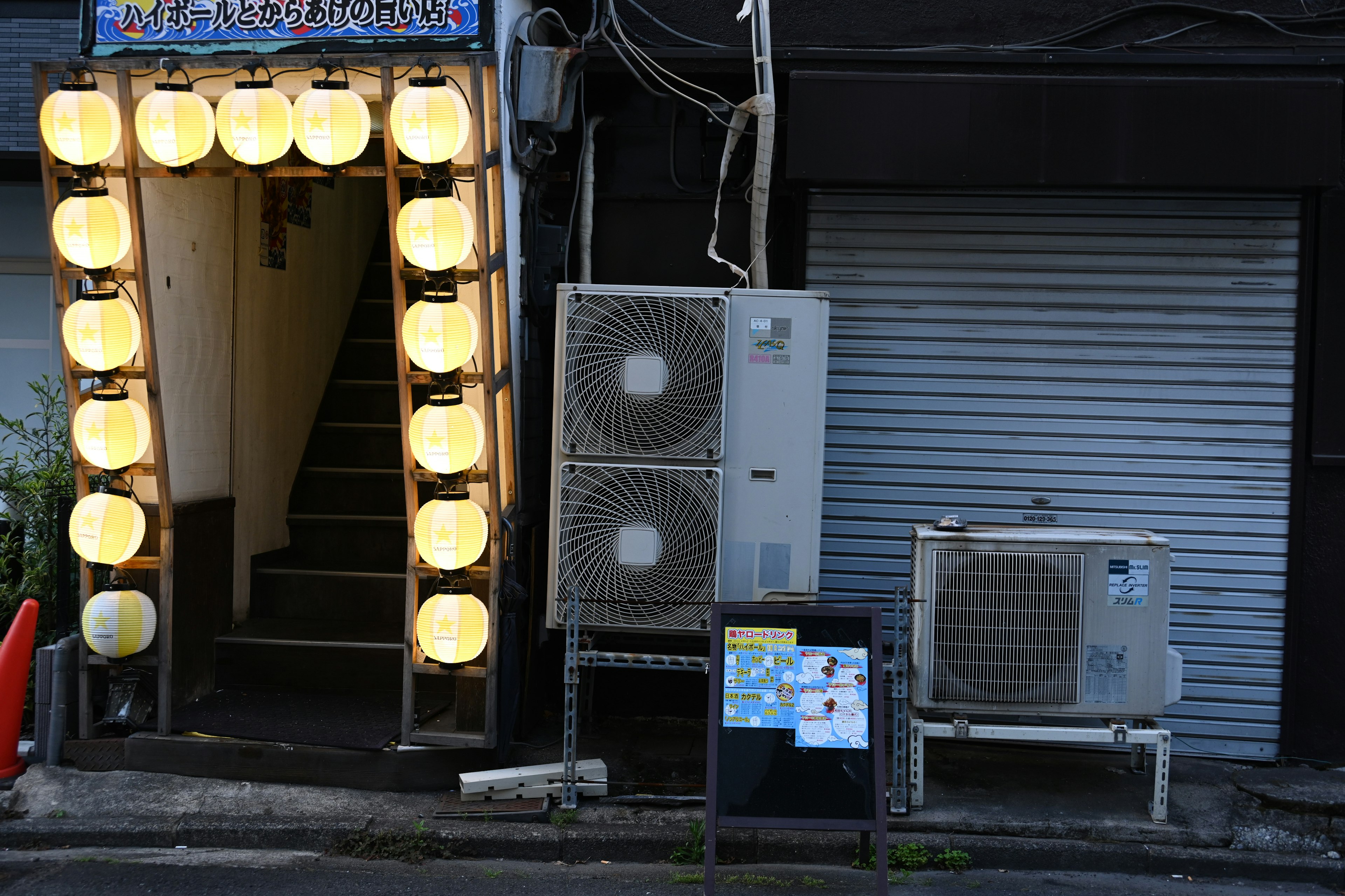 Entrance with bright lanterns leading to stairs in a Japanese shopping street