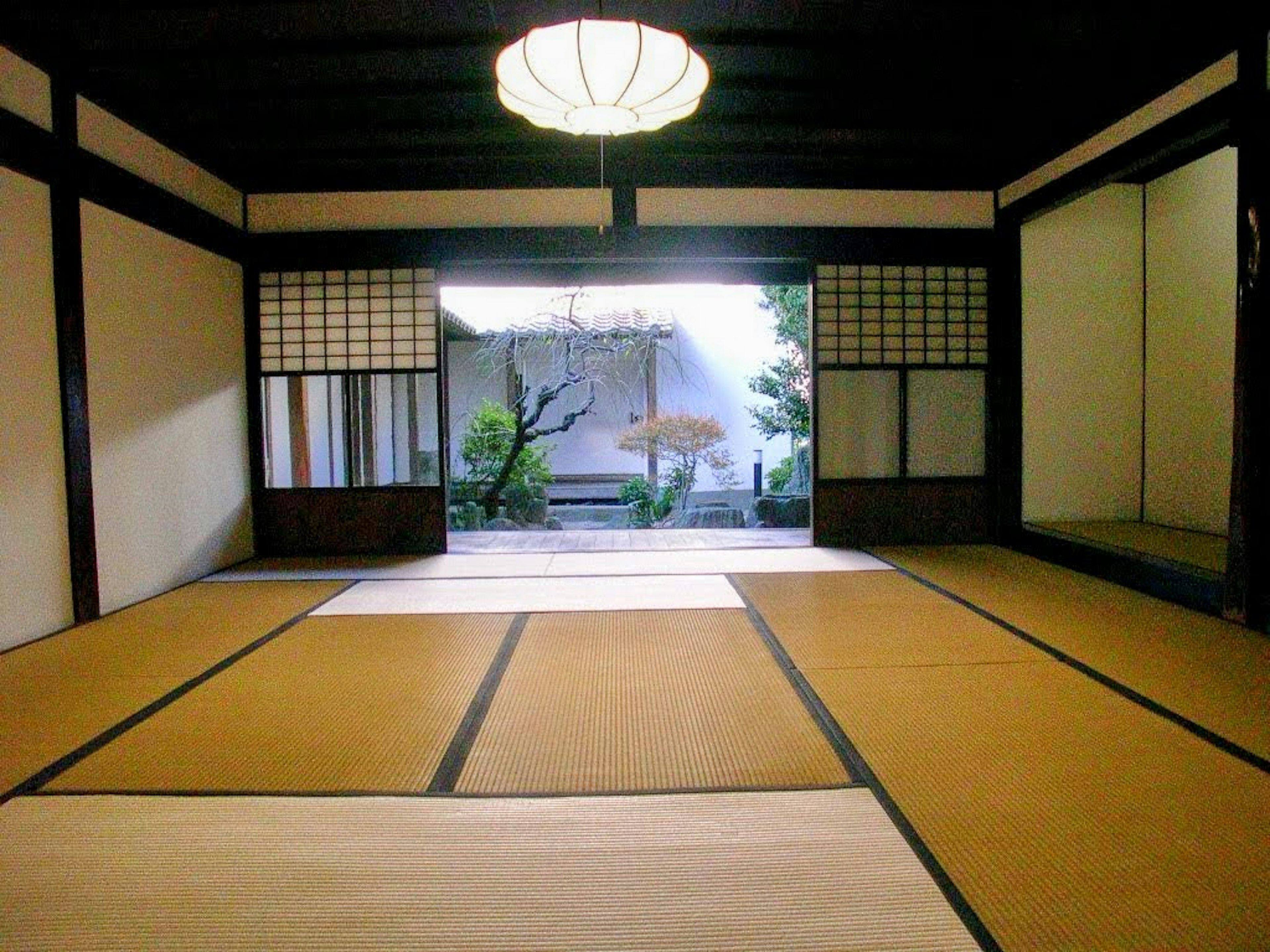 Traditional Japanese room with tatami mats and a view of a garden