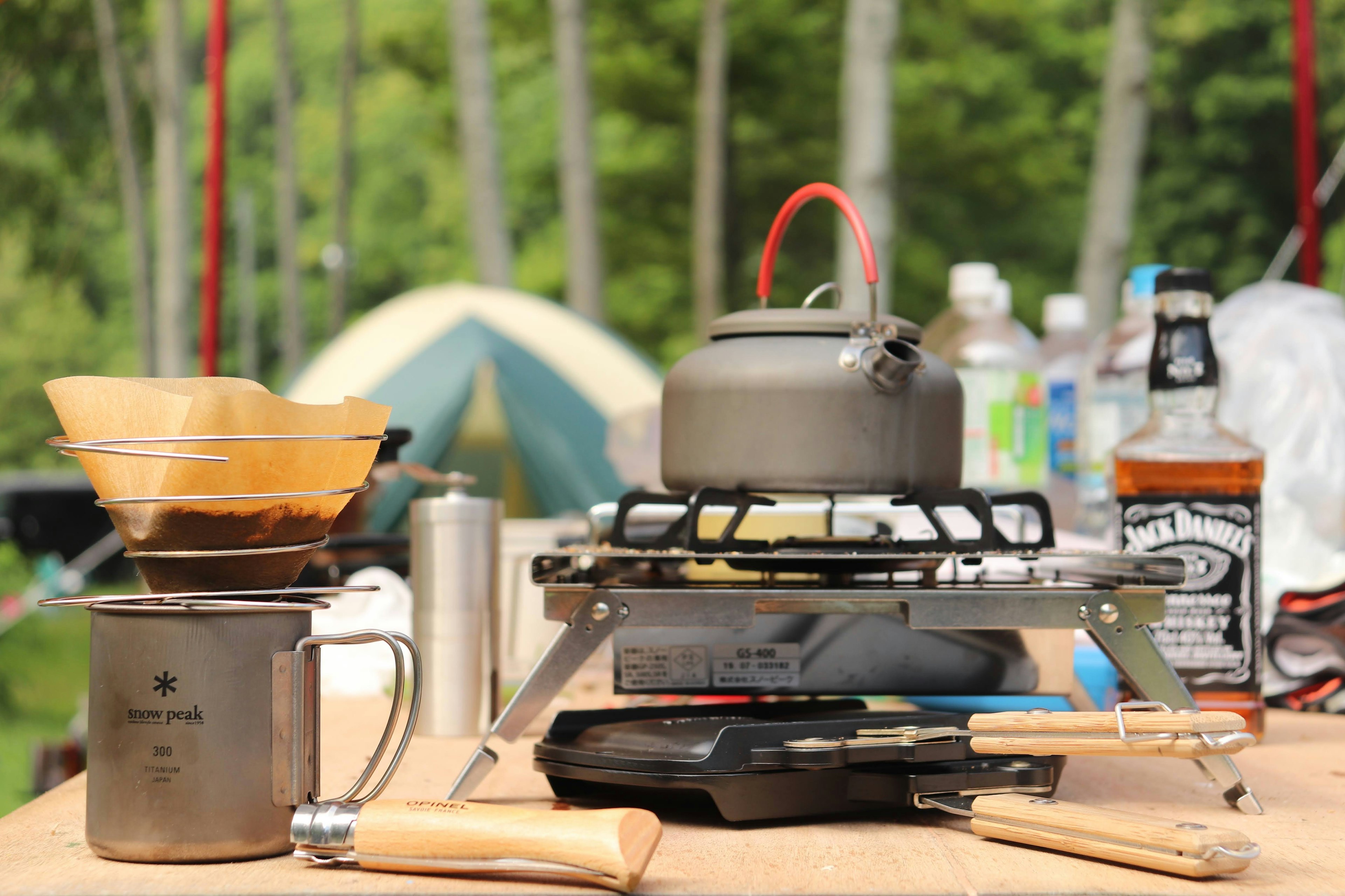 Camping setup with coffee brewing equipment on a wooden table