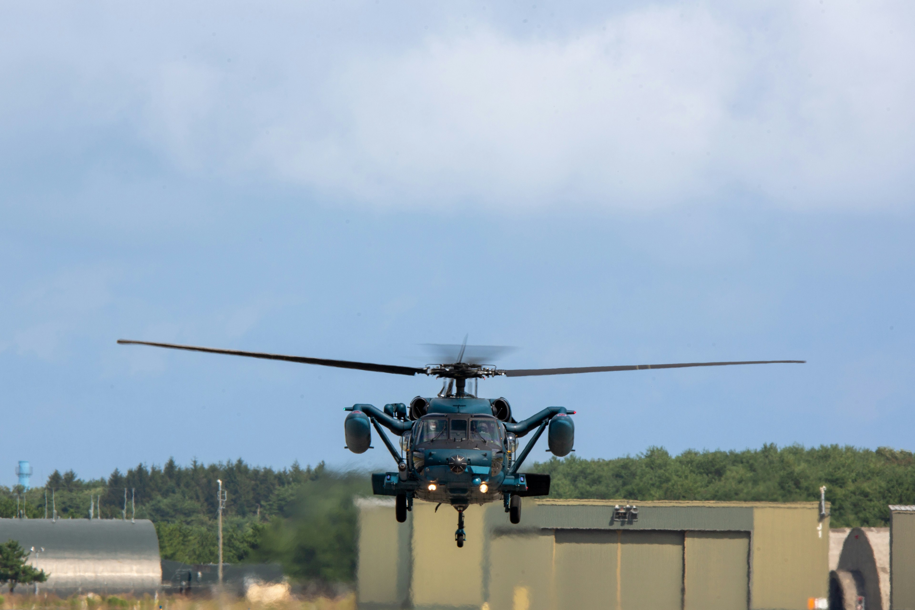 Hubschrauber landet auf der Landebahn mit klarem Himmel im Hintergrund