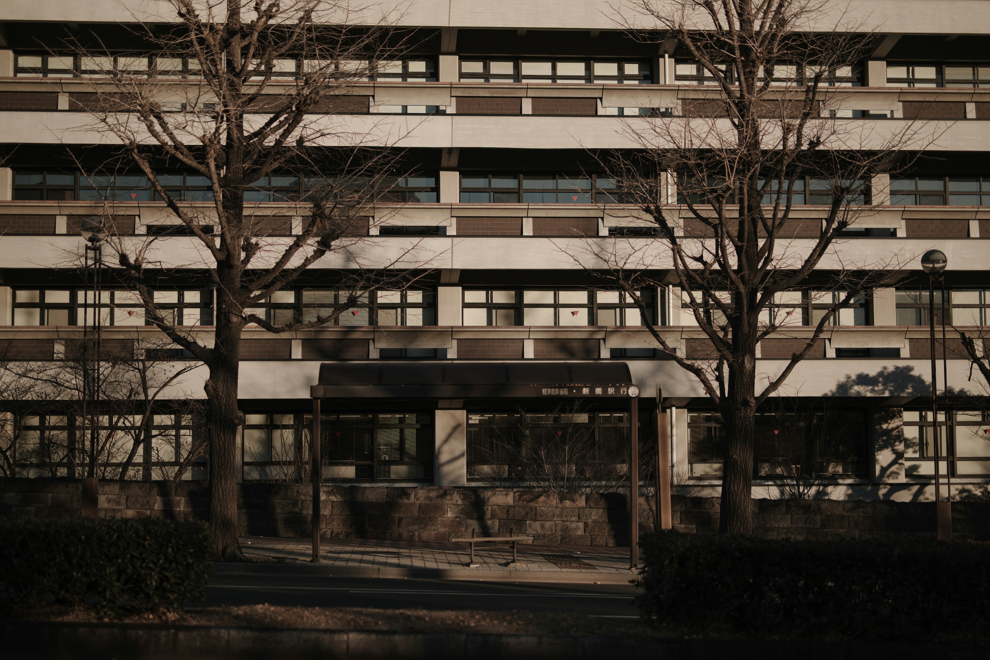 Façade d'un grand bâtiment en béton avec des arbres environnants