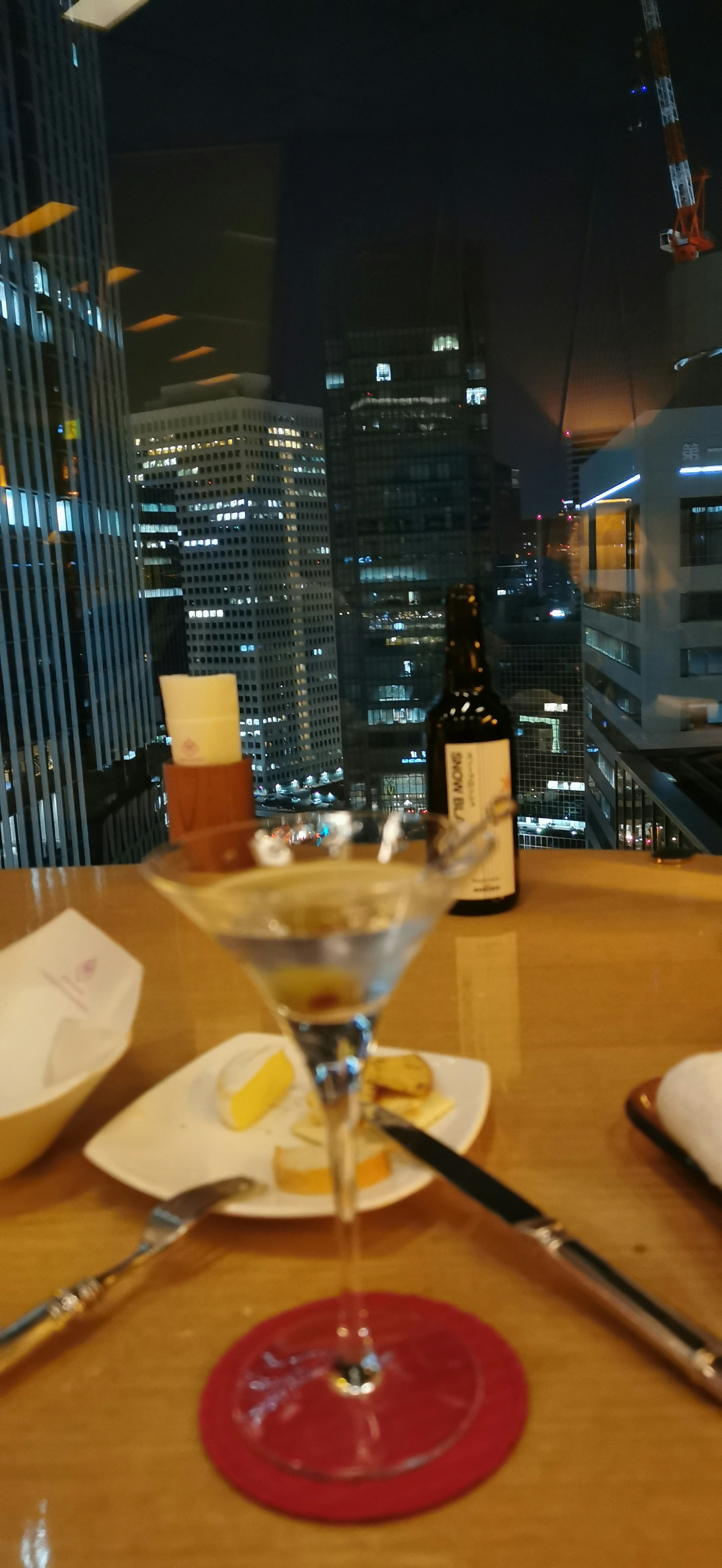 Cocktail glass with city skyline at night in the background