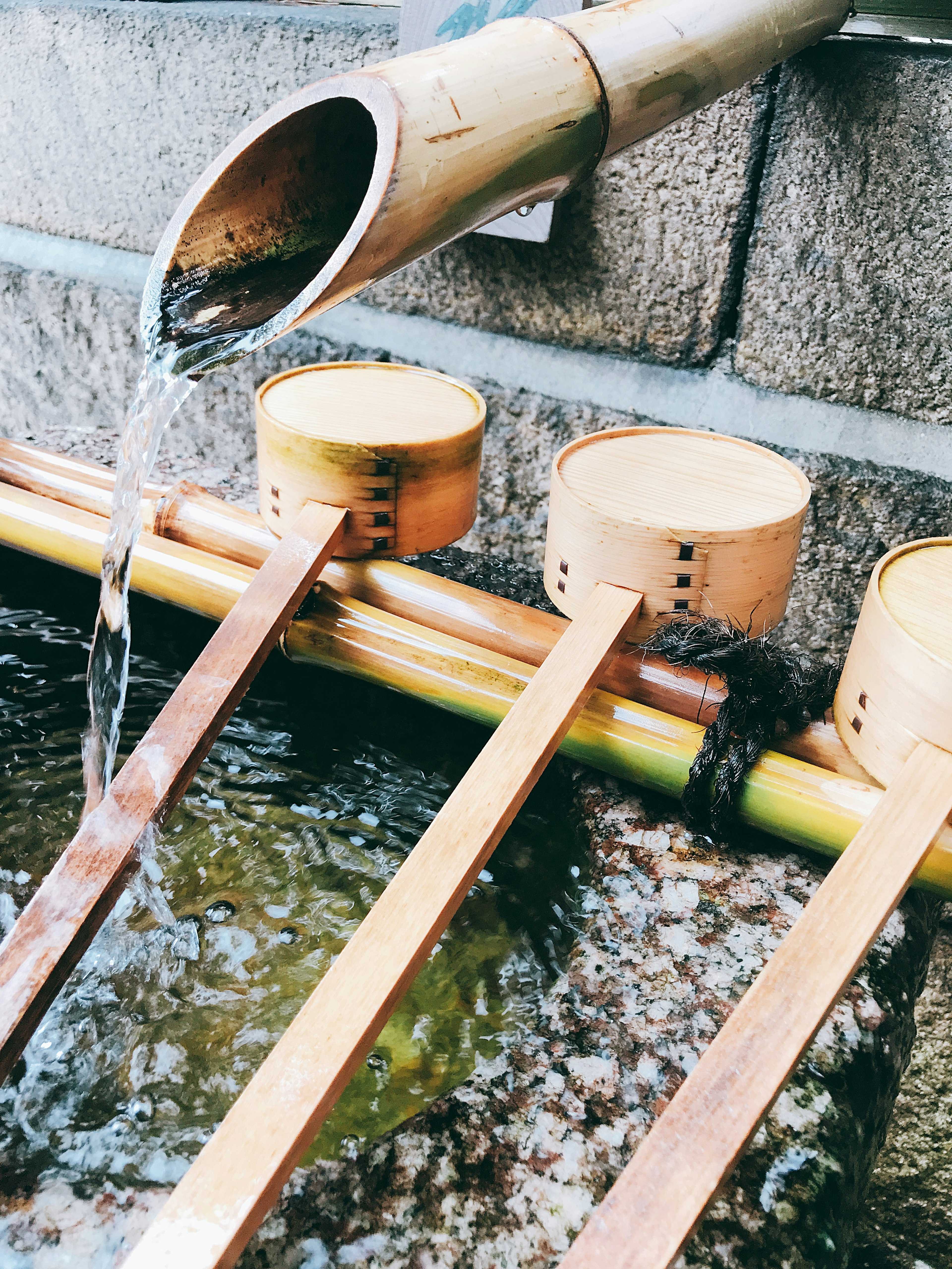 Goulotte en bambou avec des ladles en bois disposées à un site de purification