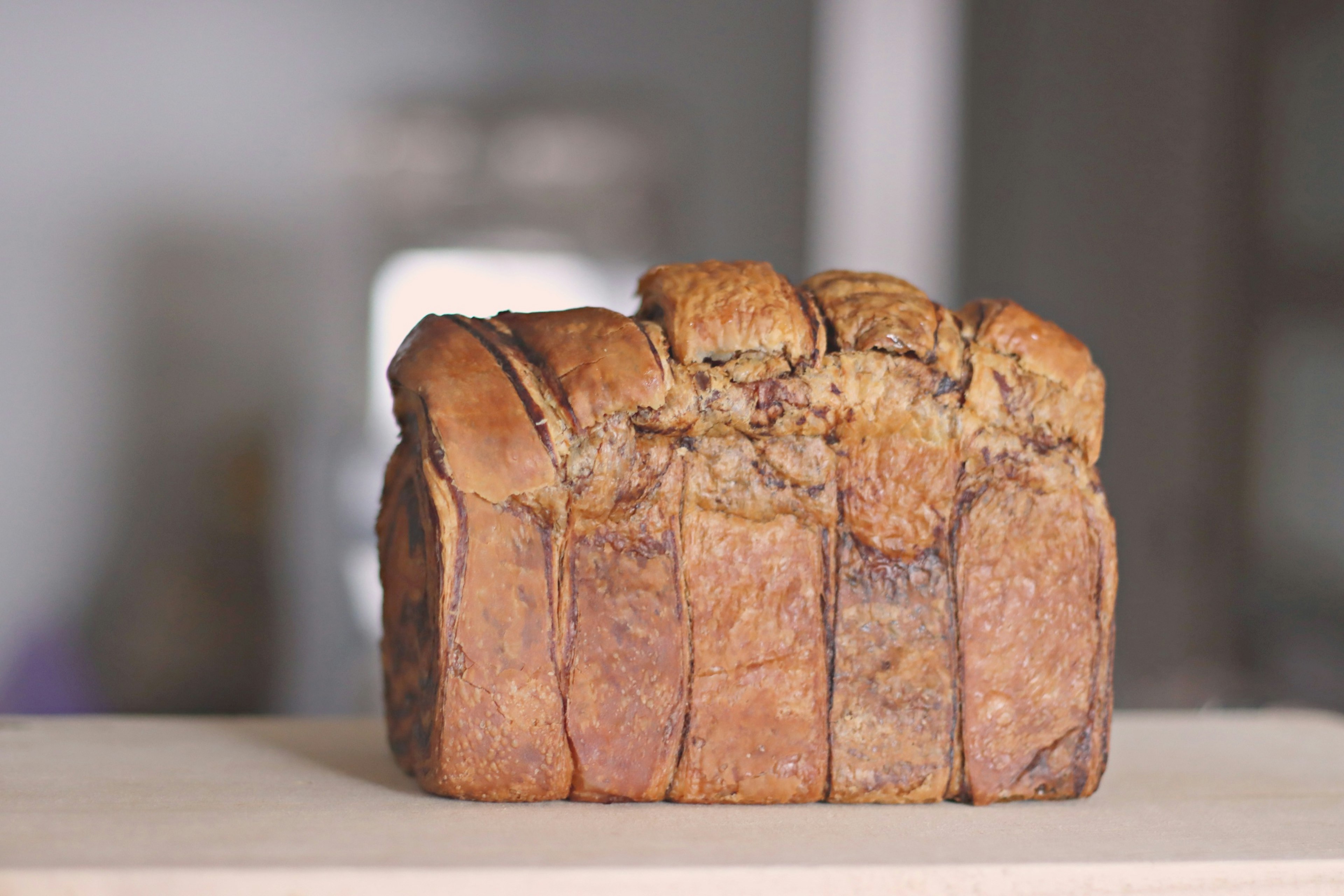 Freshly baked loaf of bread placed on a wooden surface