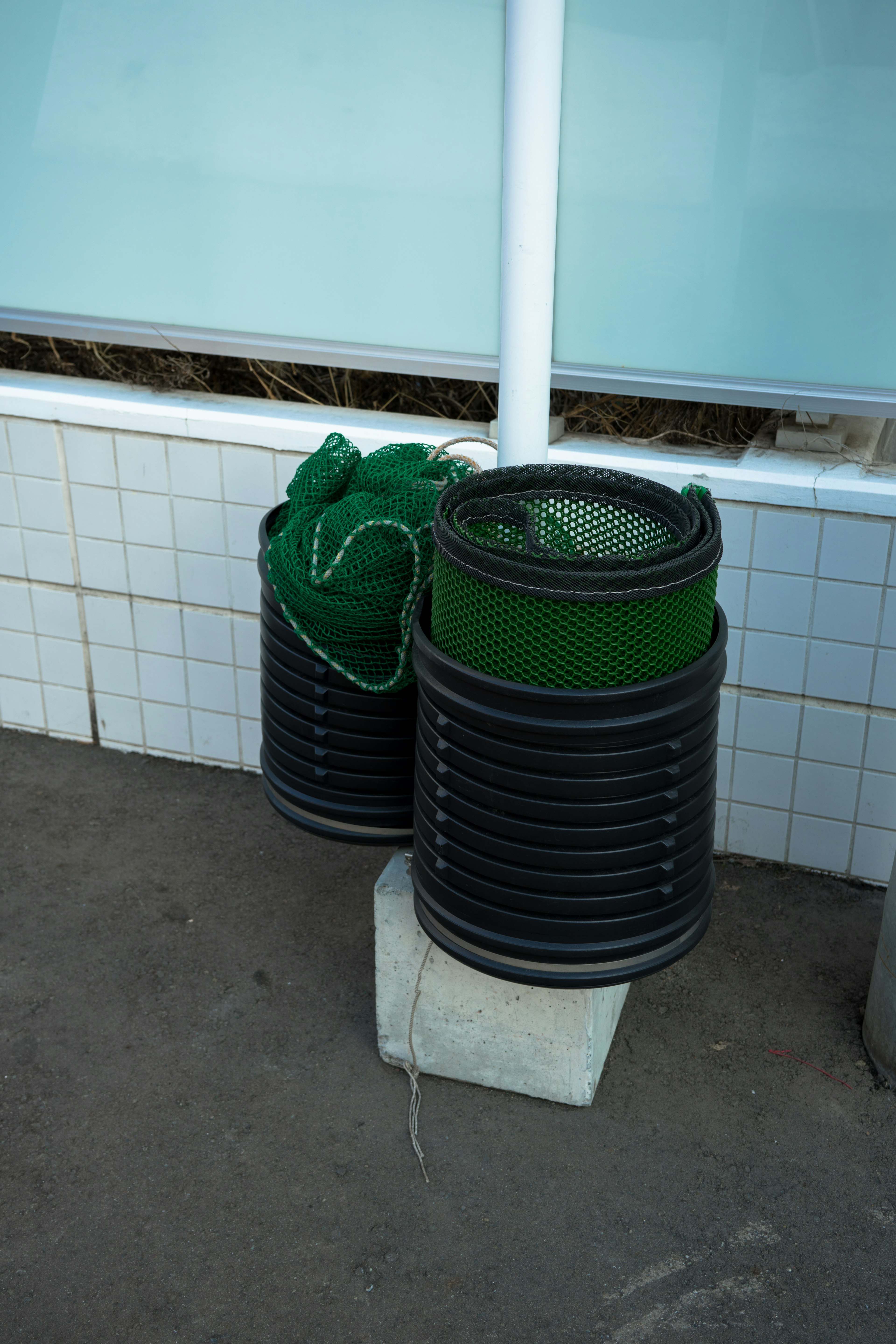 Scène extérieure avec une combinaison de poubelles noires et de sacs verts