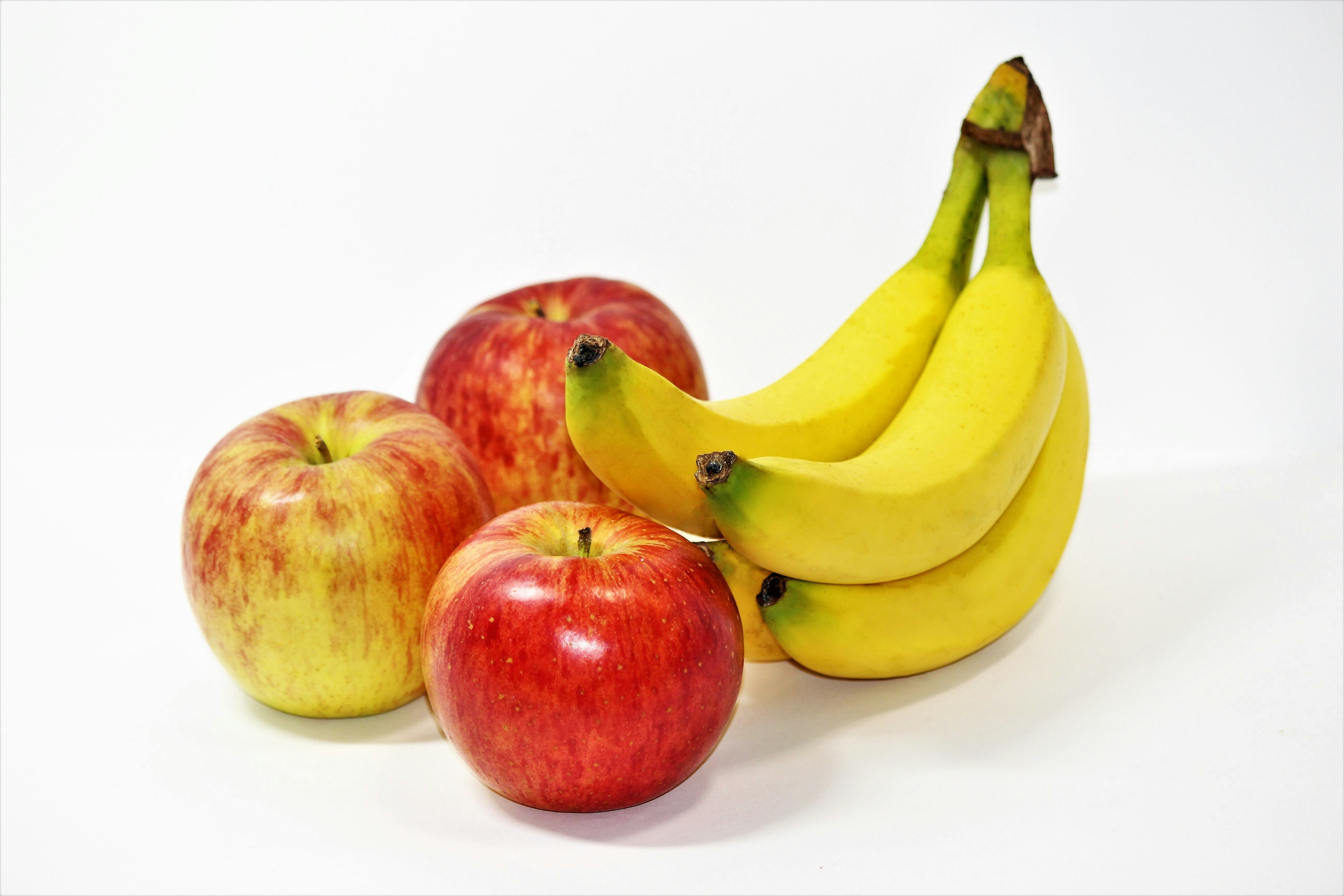 A combination of red and yellow apples with yellow bananas