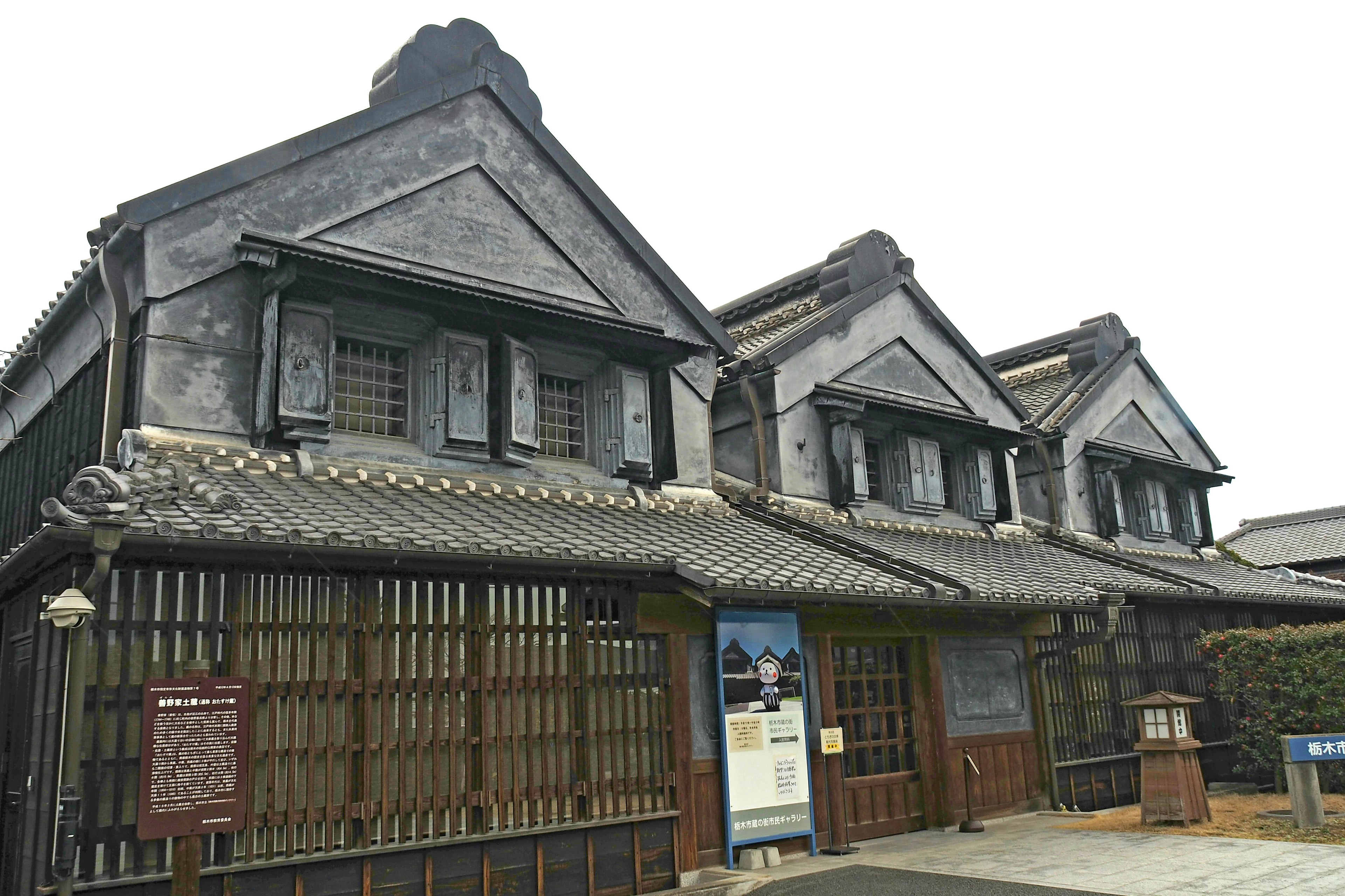 Traditional Japanese building exterior featuring tiled roof and wooden lattice