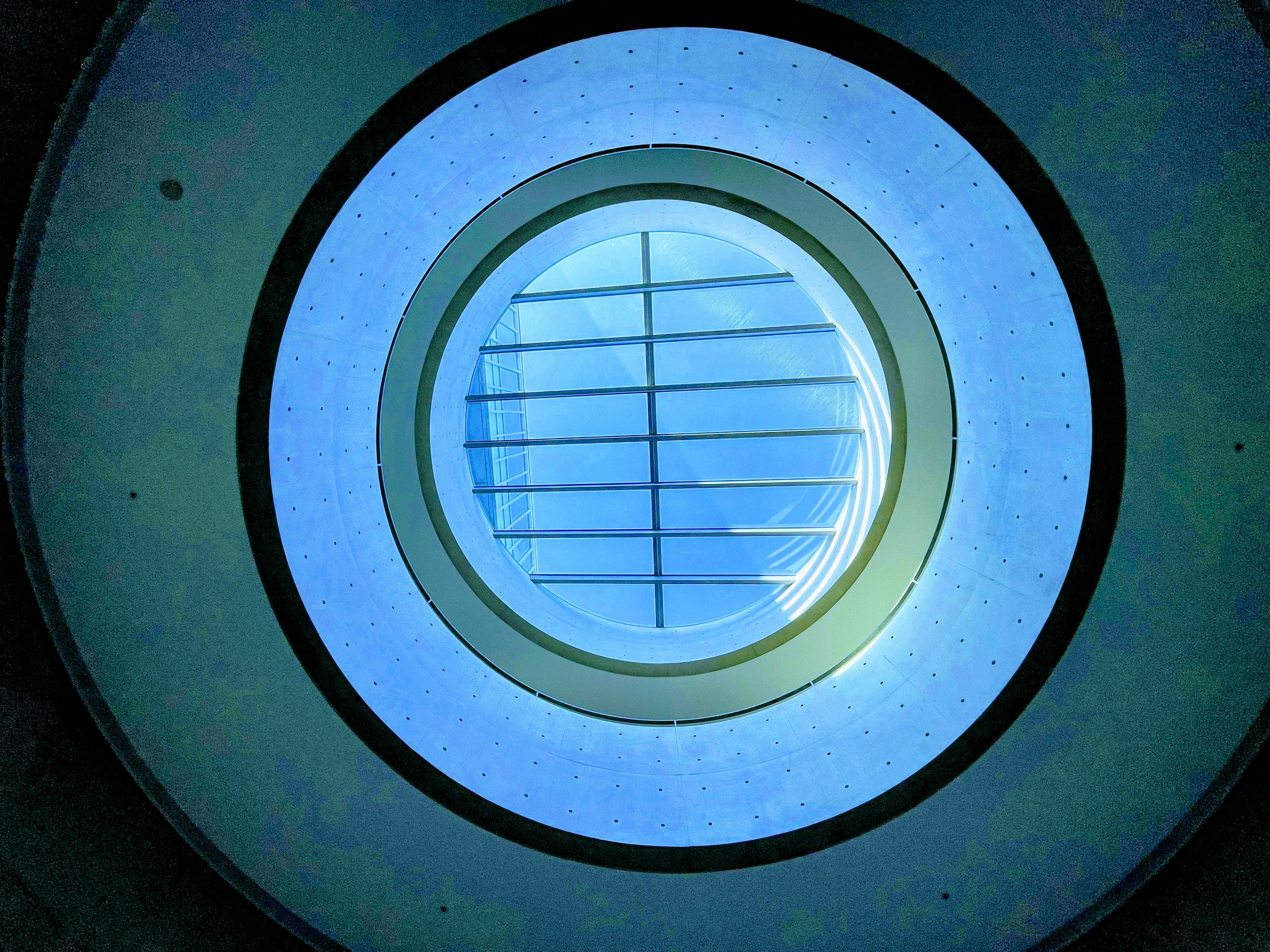 View of a circular window with blue light and grid pattern