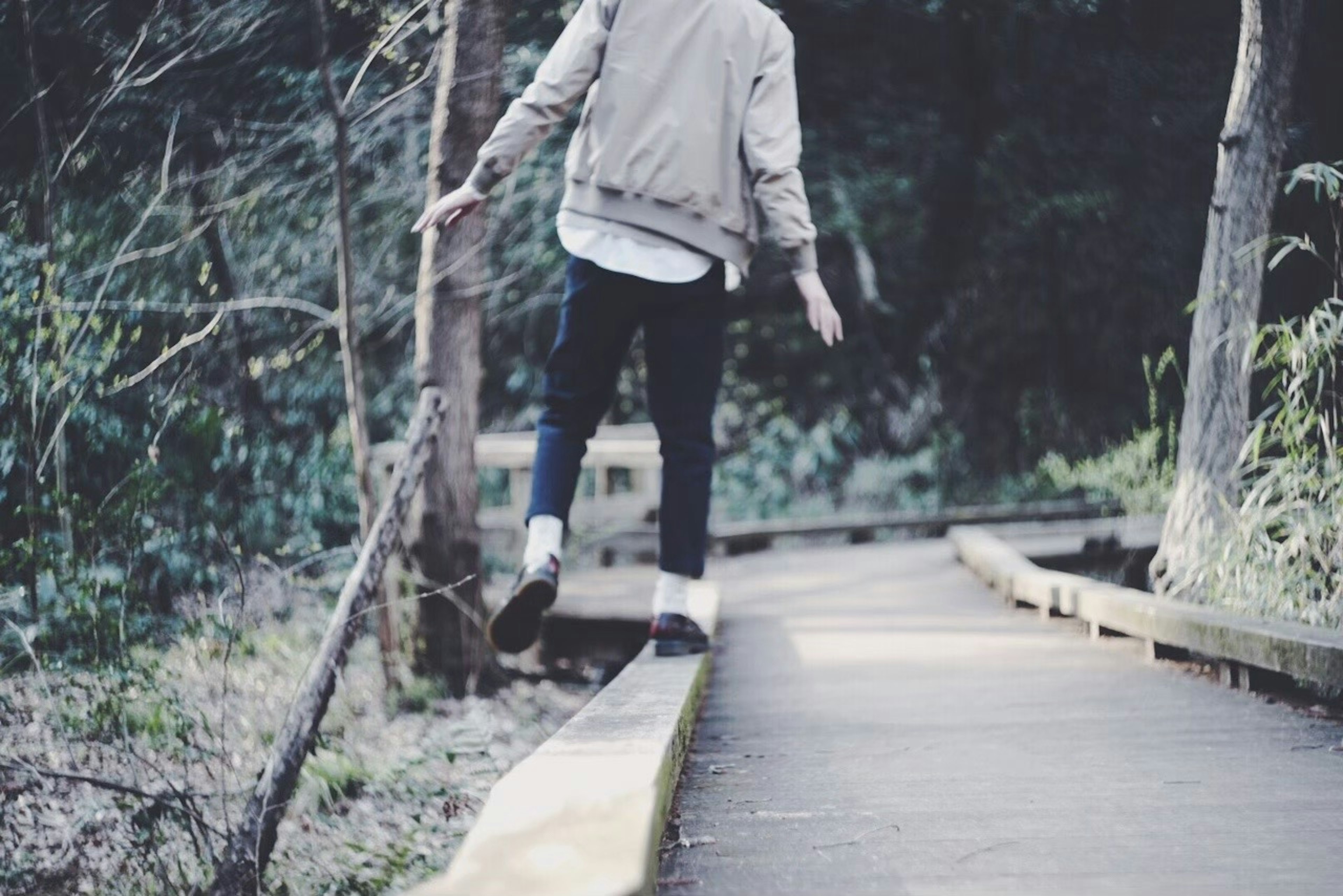 Person walking along a narrow path in the forest